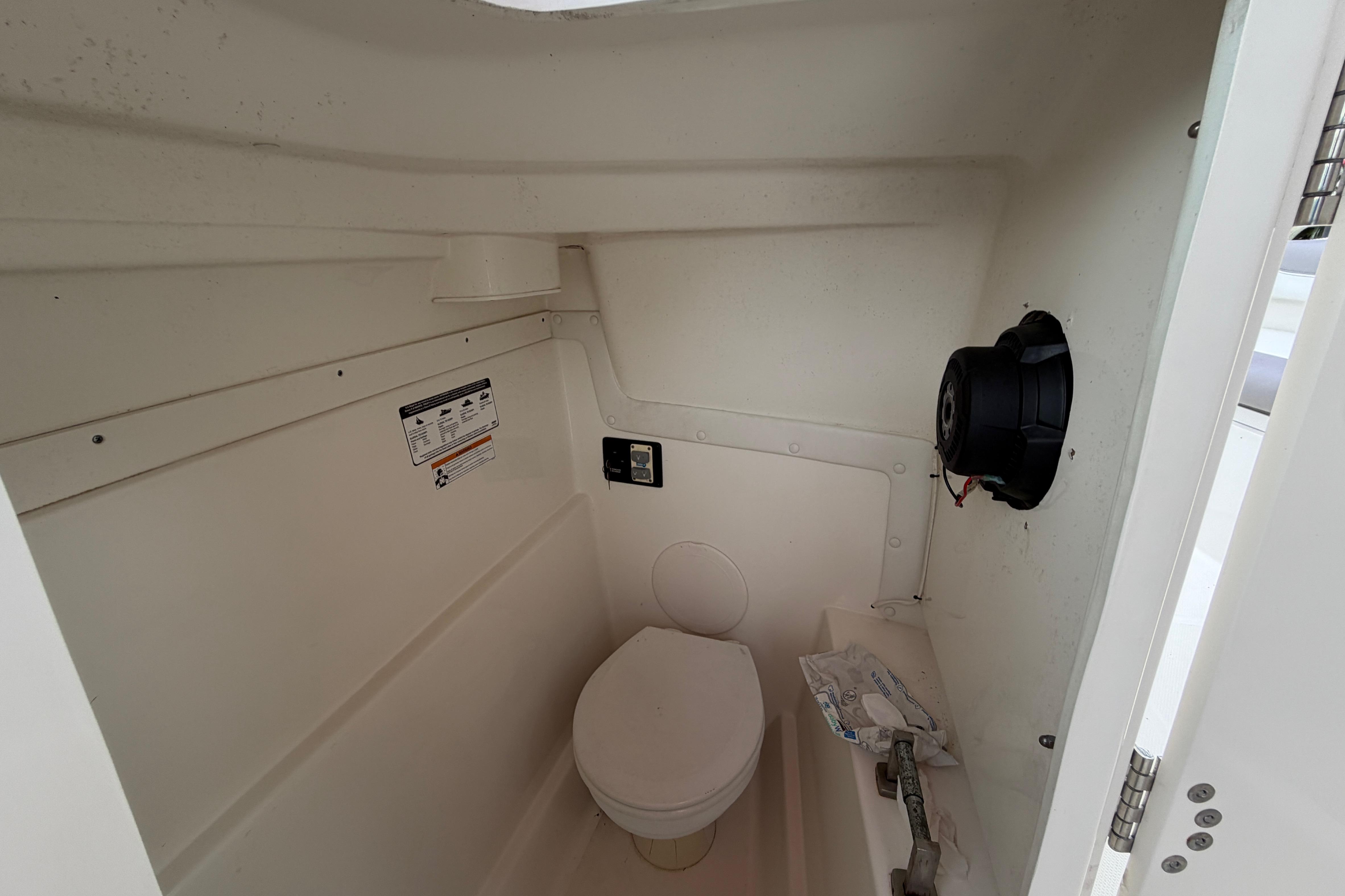 Interior of a 2019 World Cat 230 DC boat with a compact marine toilet.