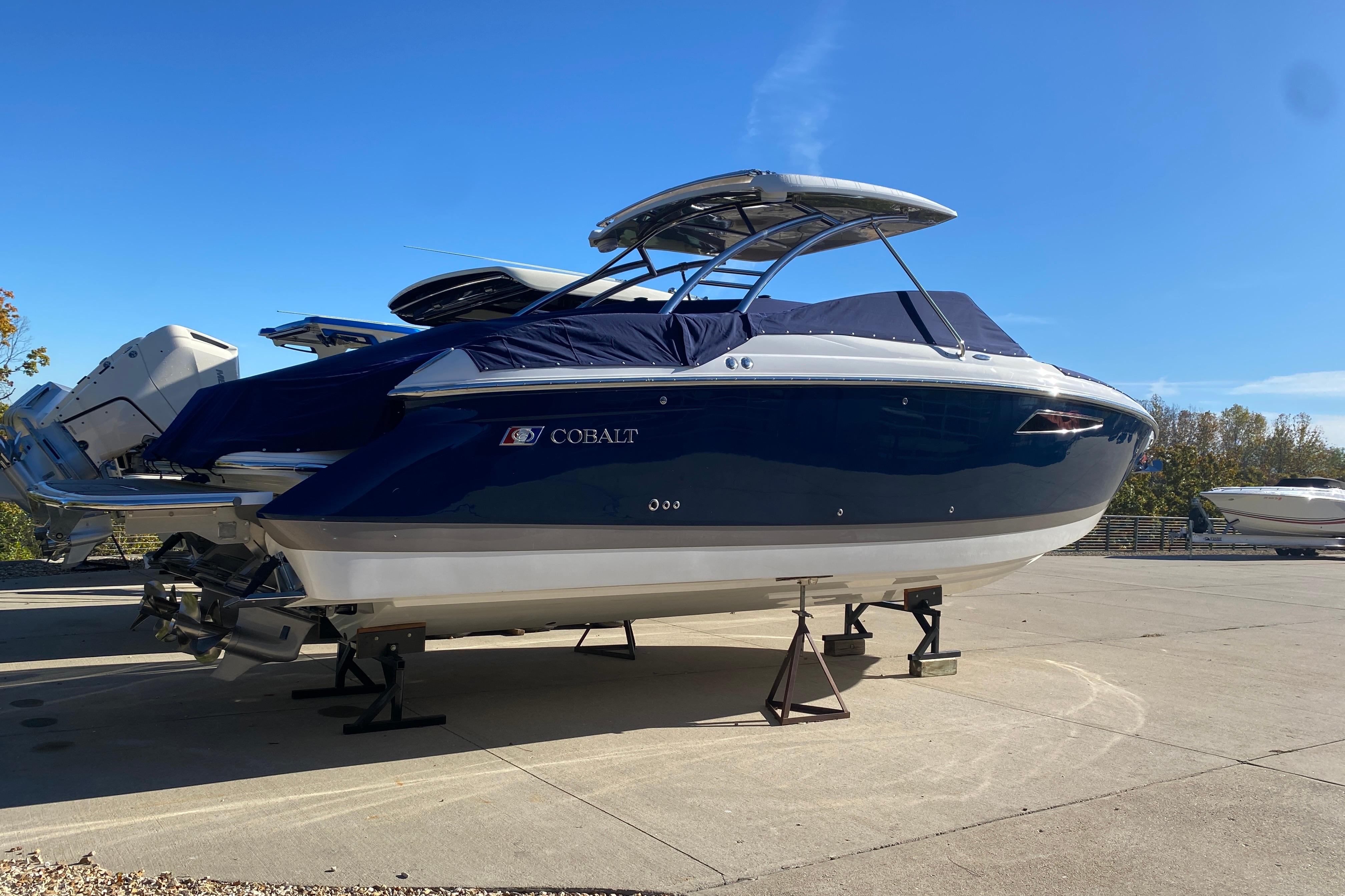 2022 Cobalt R35 boat on stands, blue and white exterior, sunny day.
