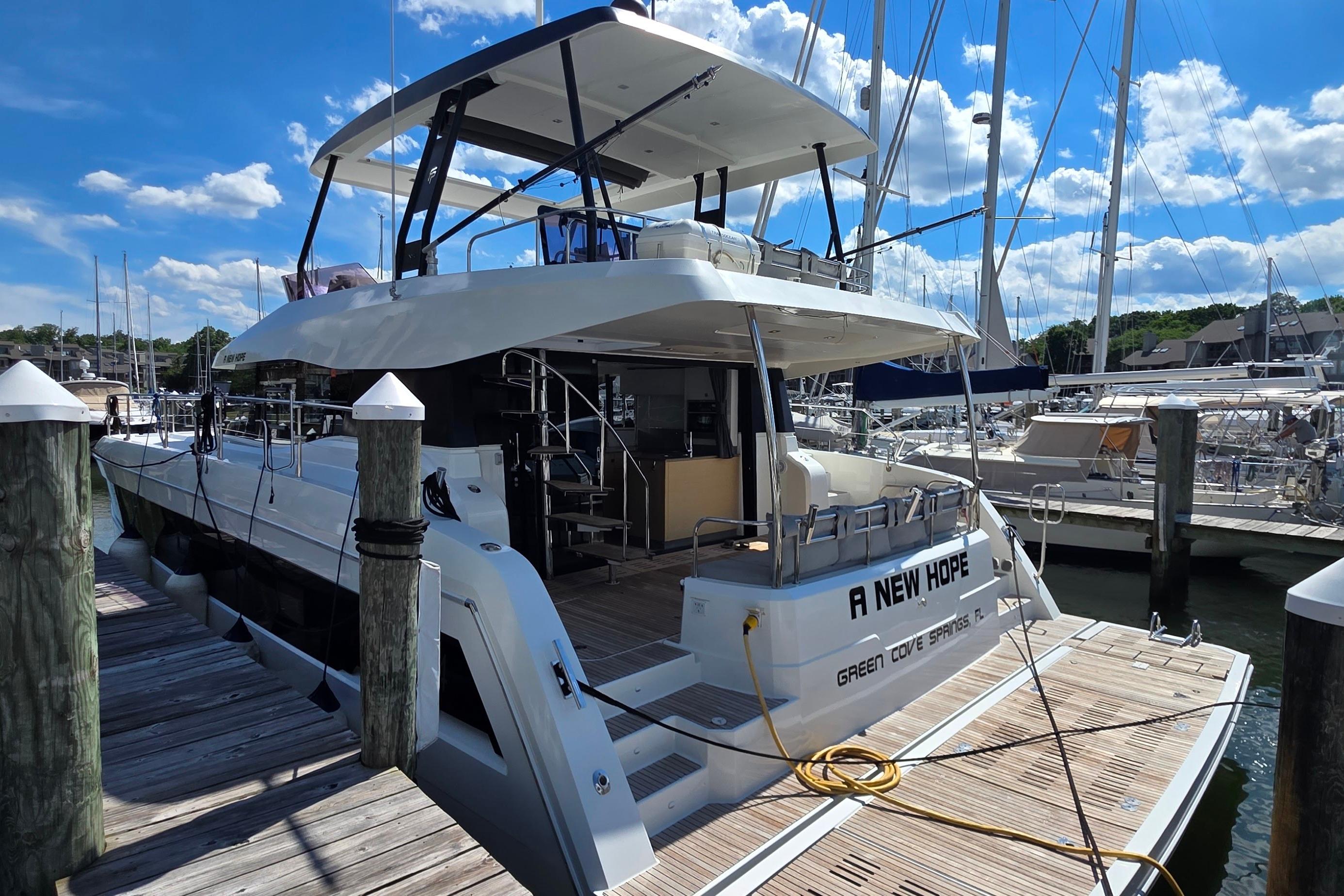 2018 Fountaine Pajot Motor Yacht 44 docked at marina under blue sky.