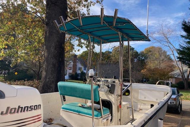 1997 Carolina Skiff 198 DLV boat with teal canopy and Johnson outboard motor.