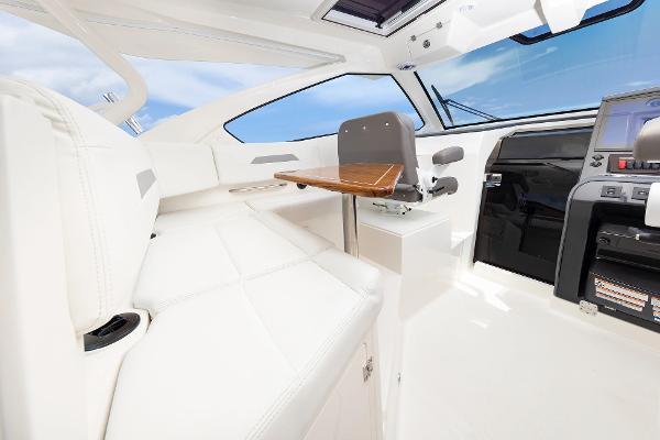 Luxurious interior of 2025 Pursuit OS 405 boat with white seating and modern controls.