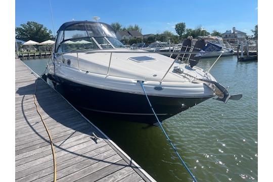 2005 Sea Ray Sundancer 320 docked at a marina on a sunny day.