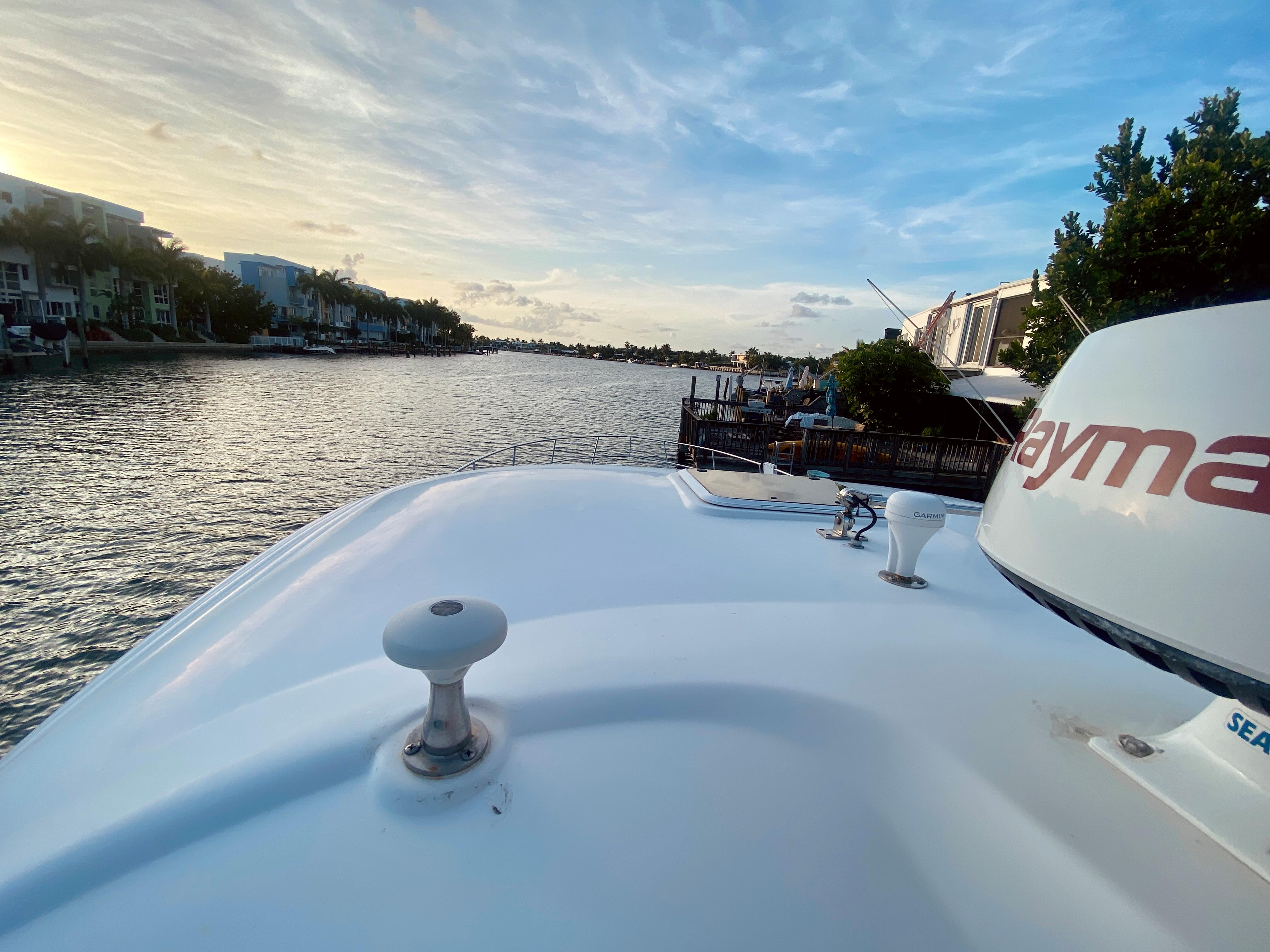 View from the bow of a 2005 Sea Ray 420 Sundancer on a serene waterway.