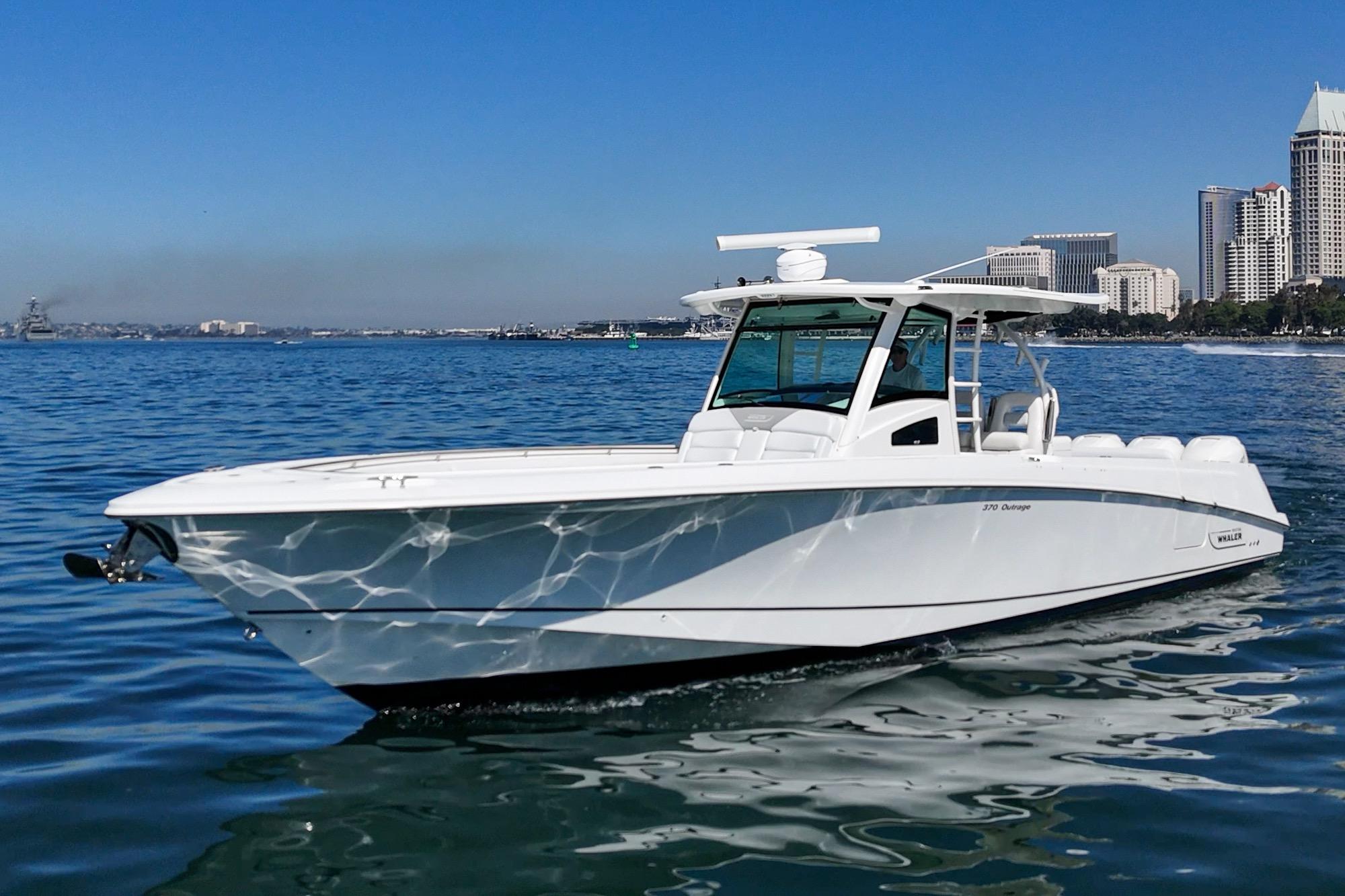 2015 Boston Whaler 370 Outrage cruising on calm waters near city skyline.