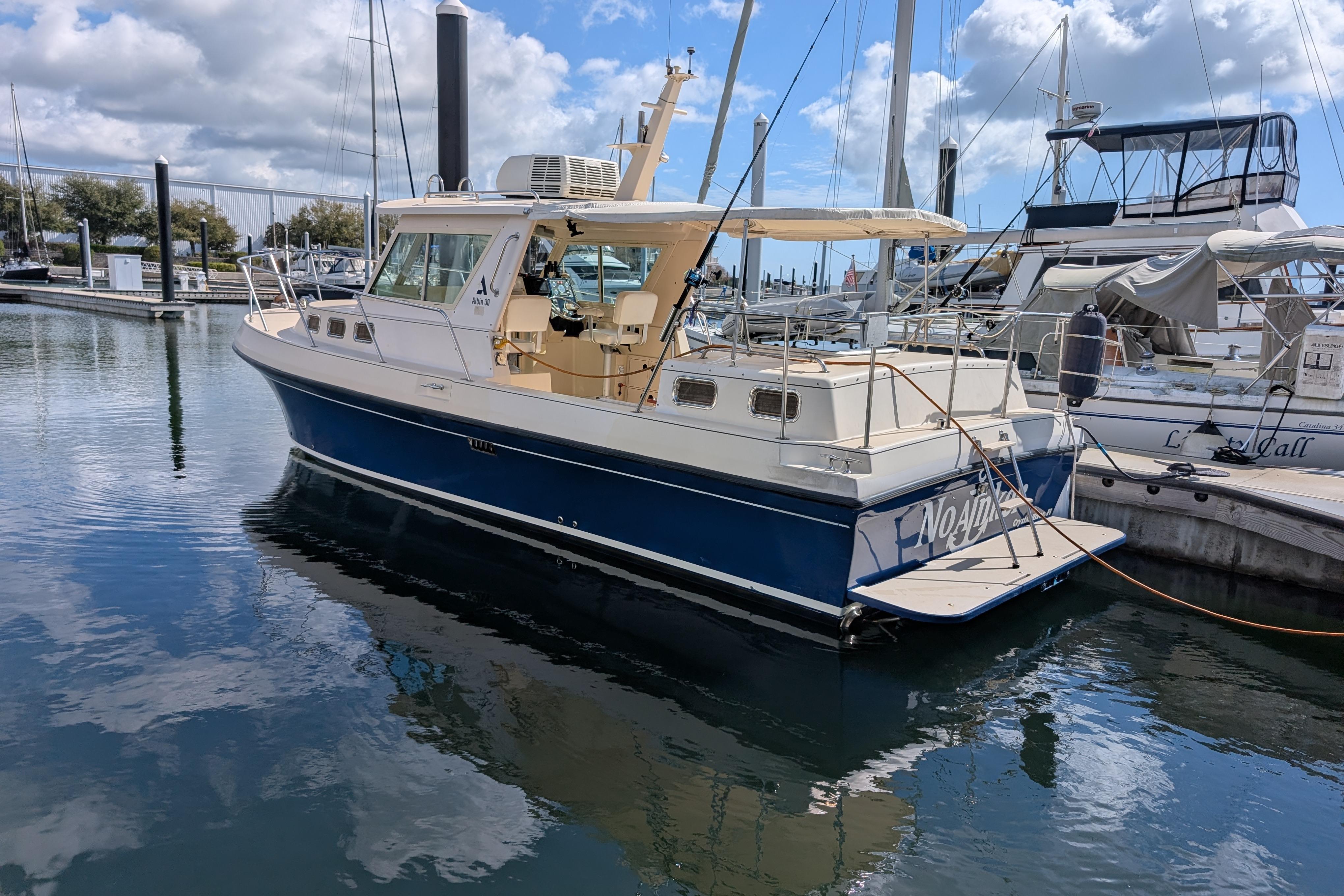2004 Albin 30 Family Cruiser docked at marina under partly cloudy sky.