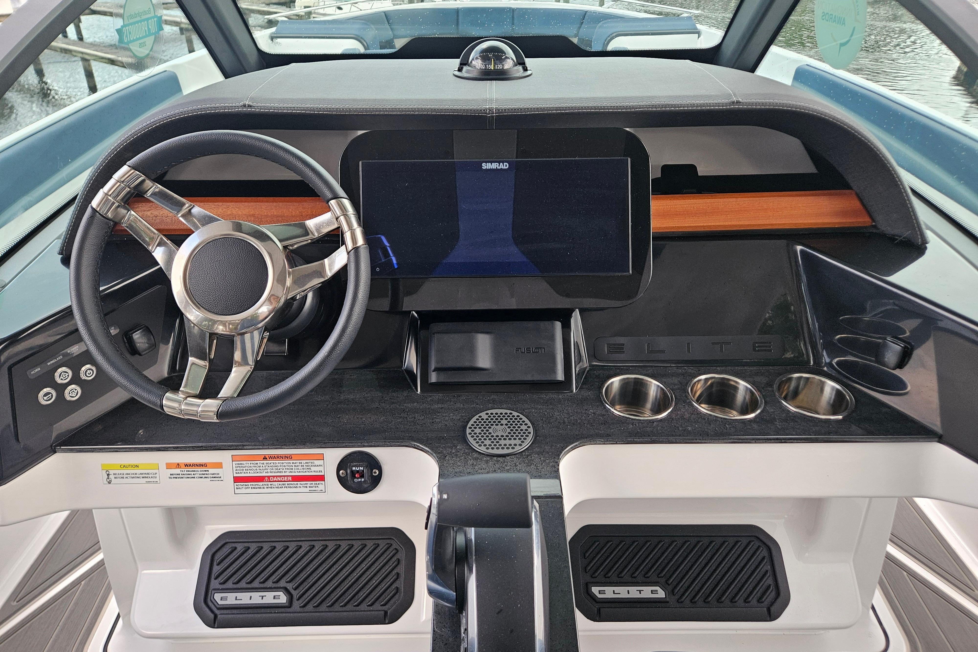 2026 Monterey Elite 27 OB boat dashboard with modern steering wheel and digital display.