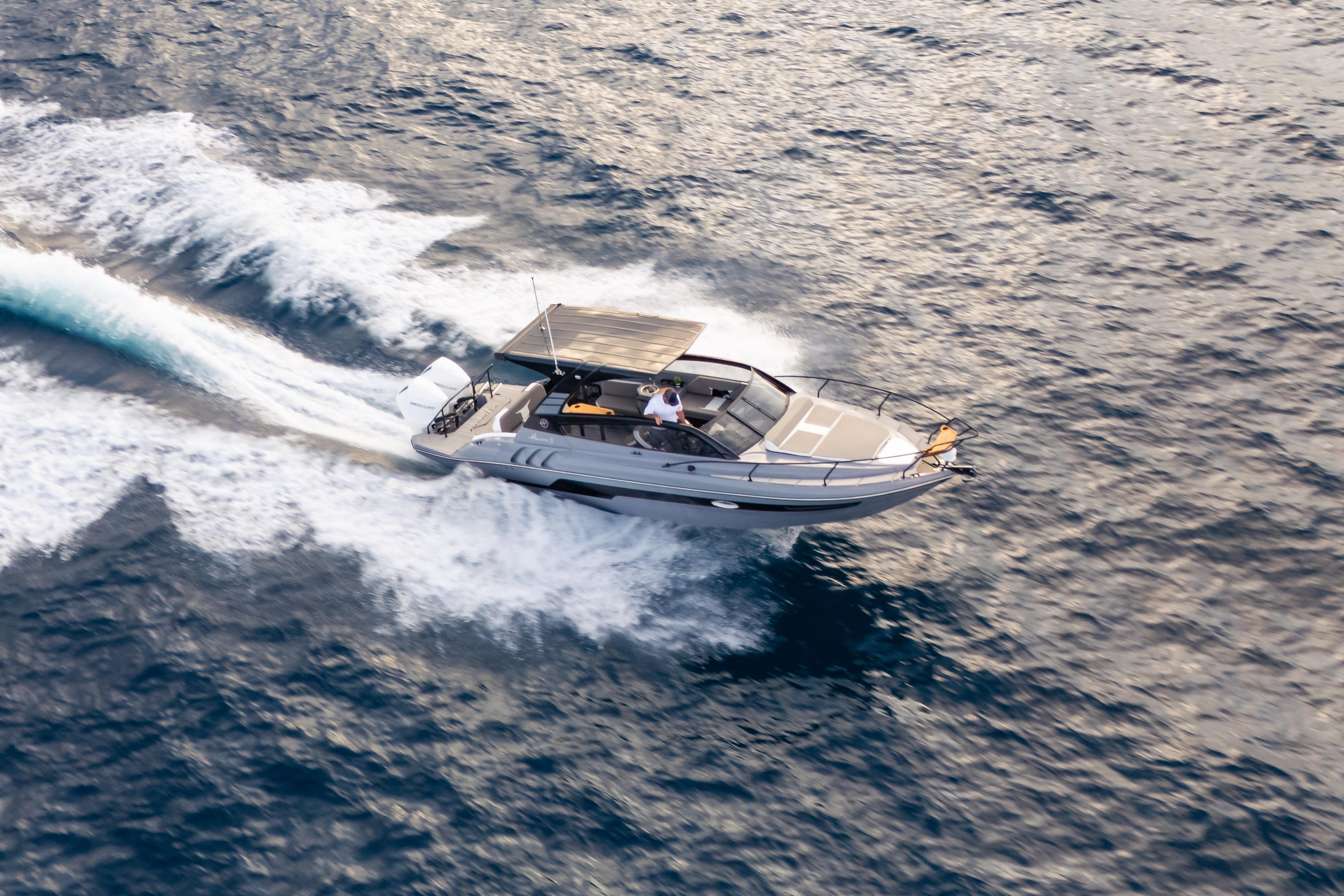 Aerial view of 2026 Hanover 305 speedboat cruising on open water.