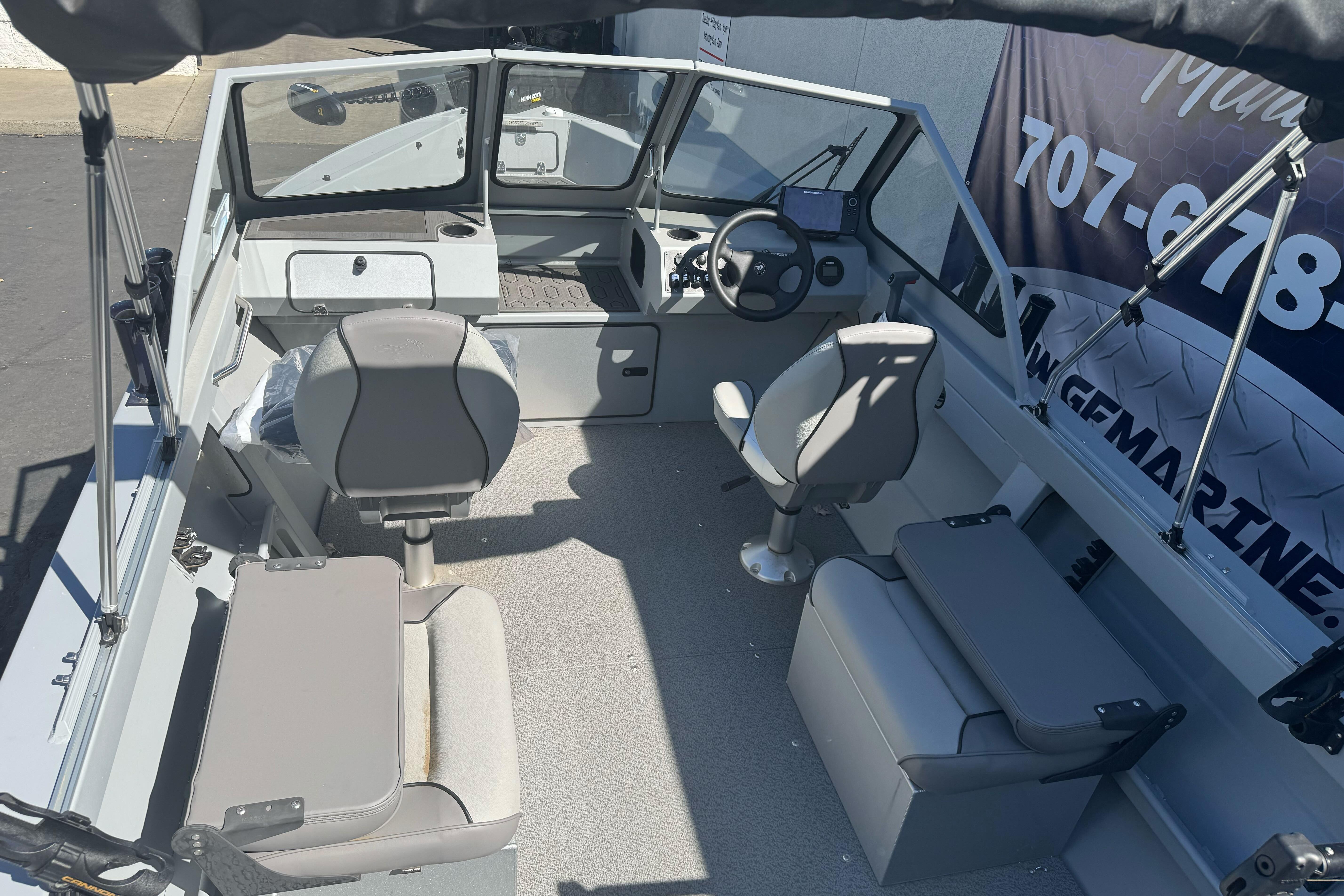 Interior of 2026 KingFisher 16 Falcon boat with seating and steering console.