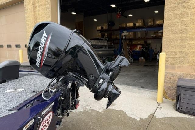2020 Tracker Pro 170 boat with Mercury outboard motor near a garage.
