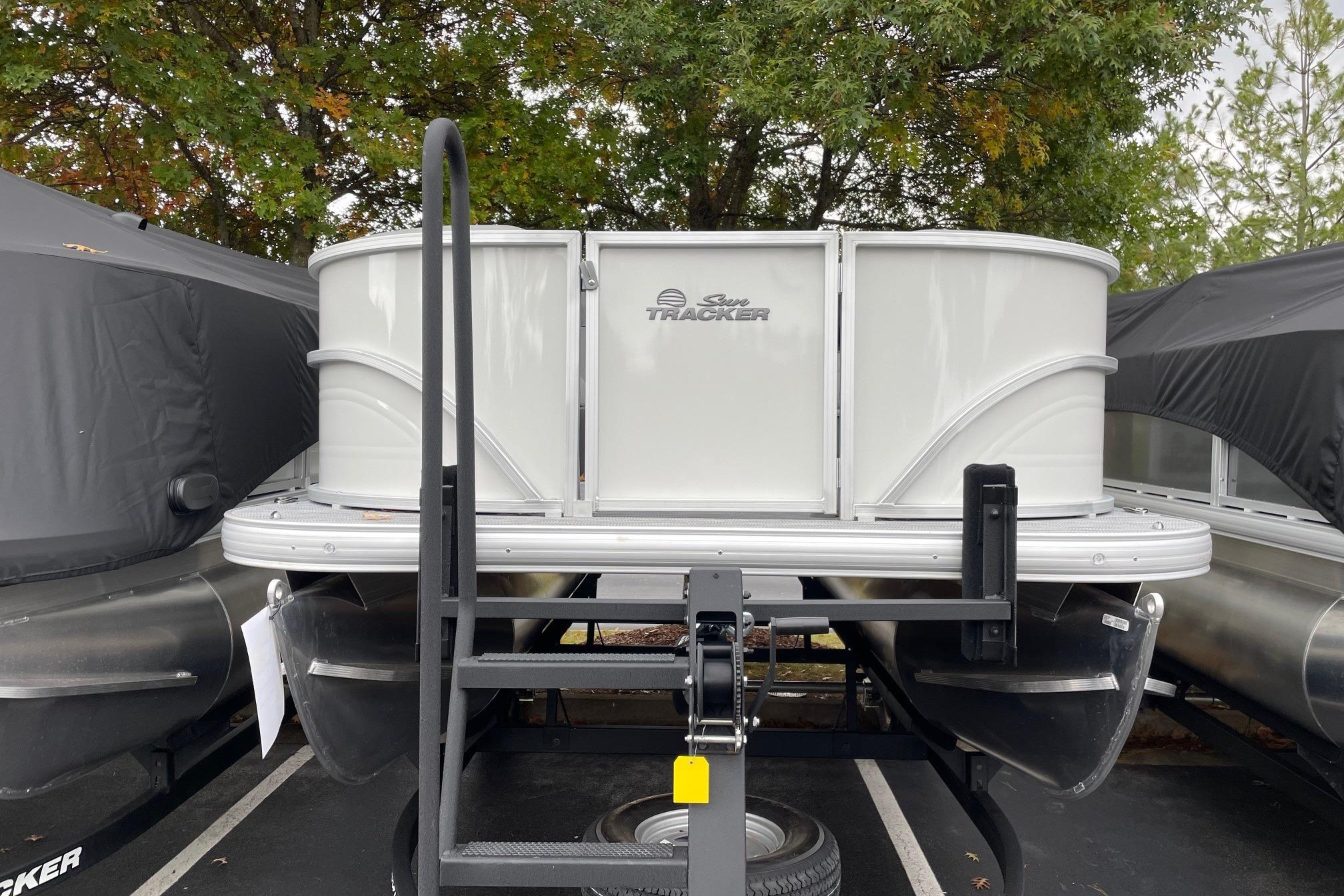 2026 Sun Tracker Party Barge 16 DLX pontoon boat on trailer, parked outdoors.