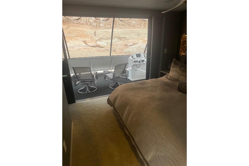 Luxurious bedroom on Adonia's 2021 "The Queen Elizabeth" yacht with scenic window view.