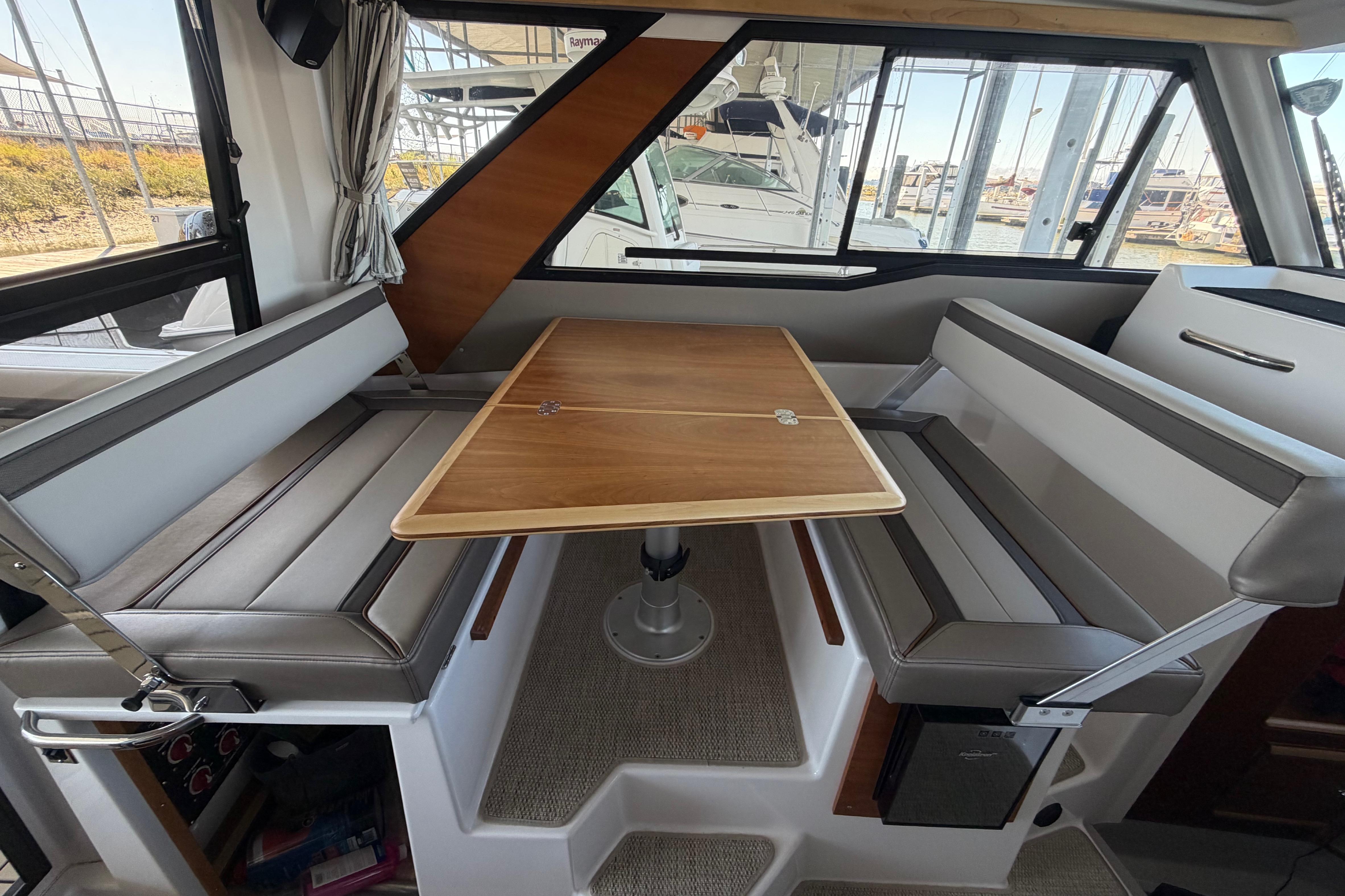 Interior of 2023 Cutwater C-288 Coupe featuring a stylish dining area with wood table.