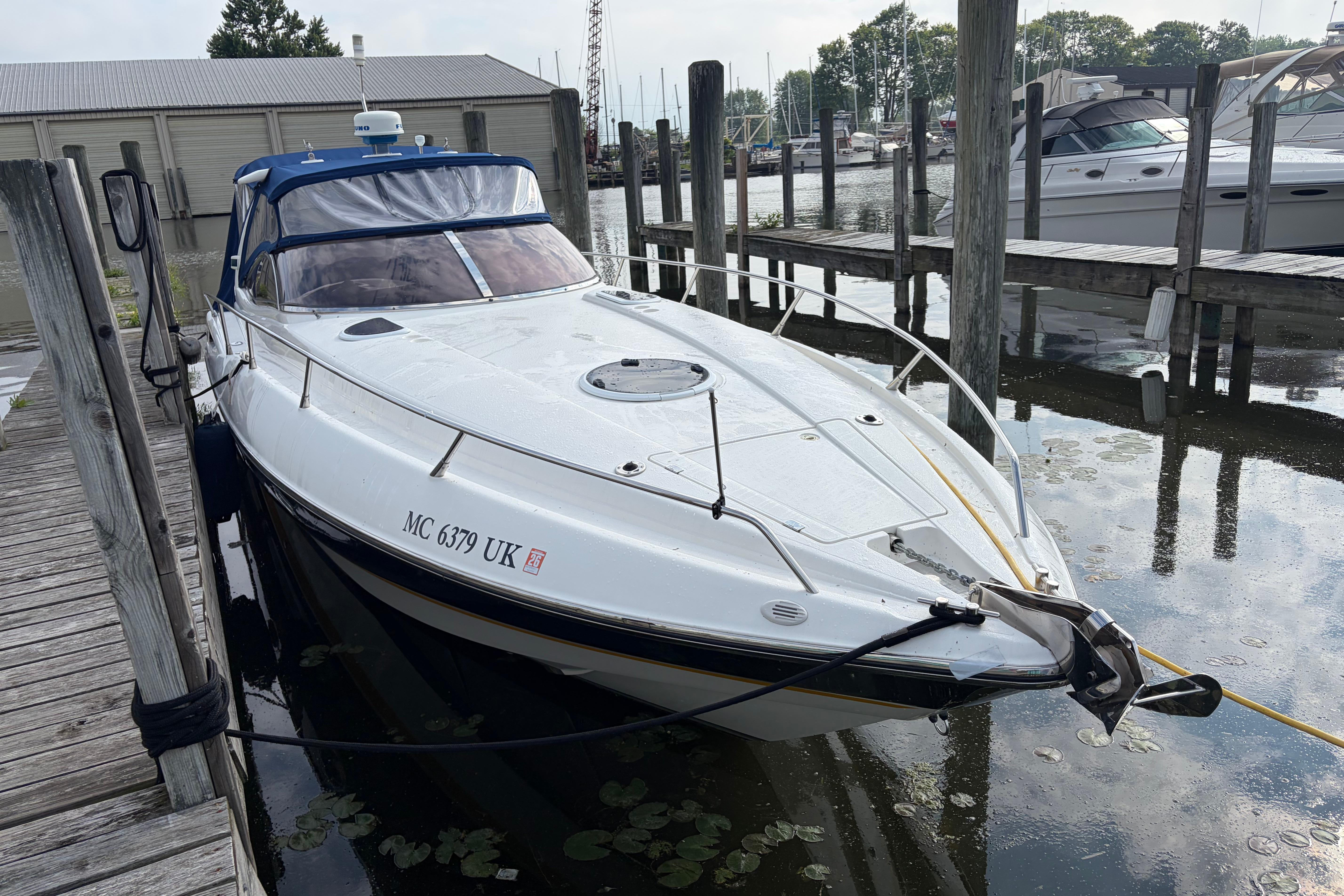 Sunseeker Superhawk 34, 2000 model, docked at a marina with surrounding boats.
