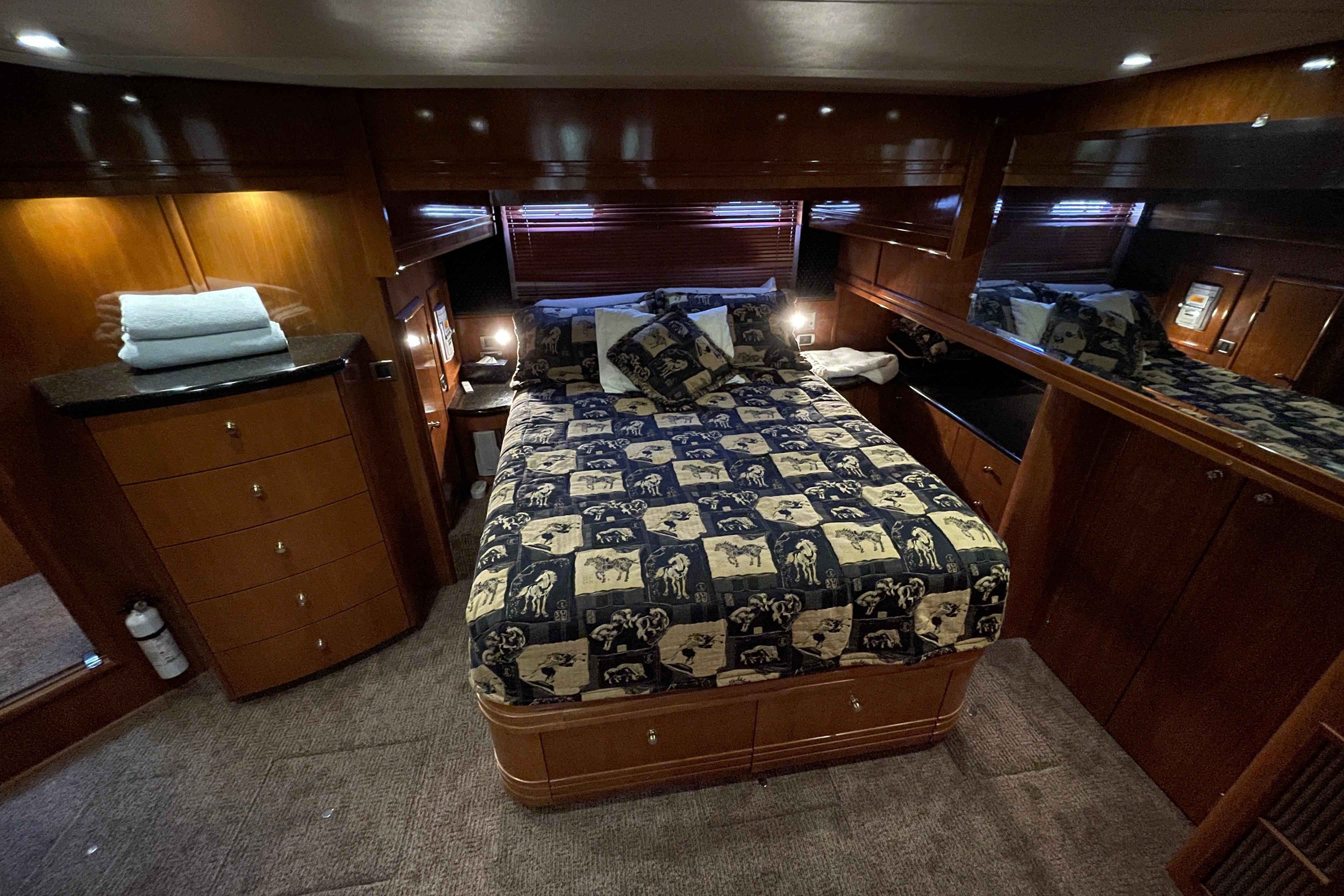 Luxurious bedroom in 2002 Carver 570 Voyager Pilothouse yacht with elegant wood finishes.