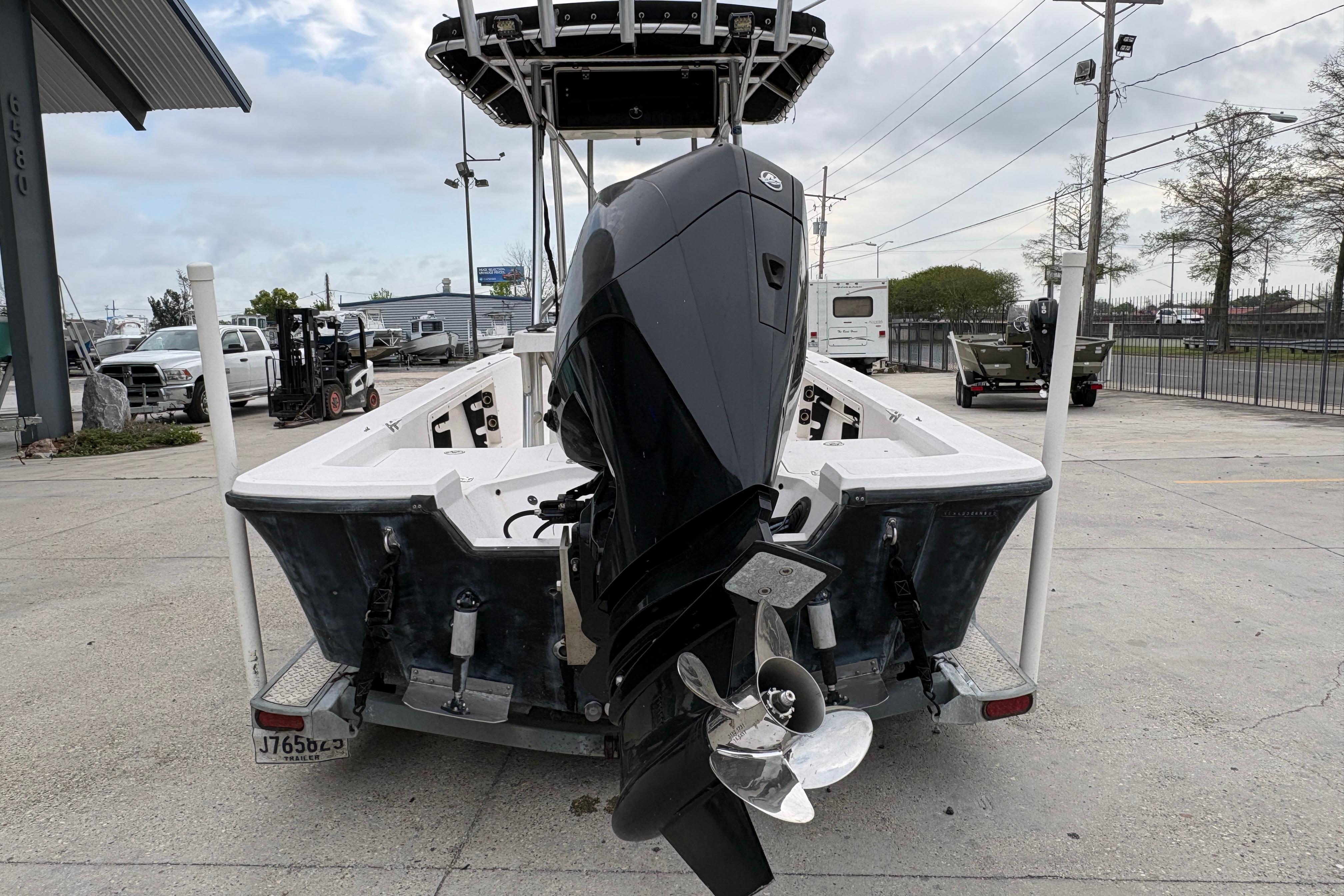 2000 Kenner 21 VISION boat with outboard motor on trailer in parking lot.