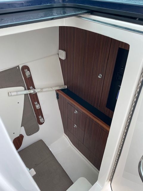 Interior of a 2015 Pursuit DC 325 Dual Console with wood paneling and storage space.
