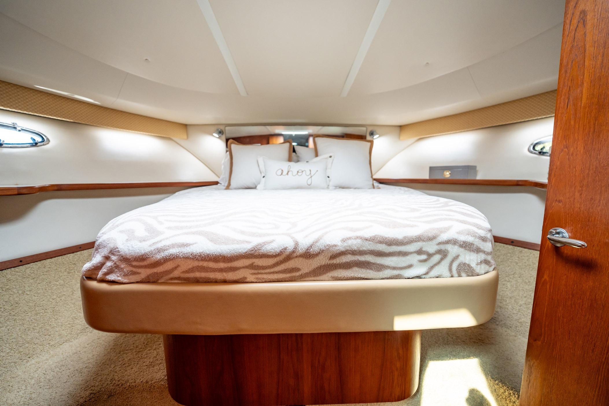 Luxurious cabin interior of 2002 Tiara Yachts 4100 Open with cozy bedding.