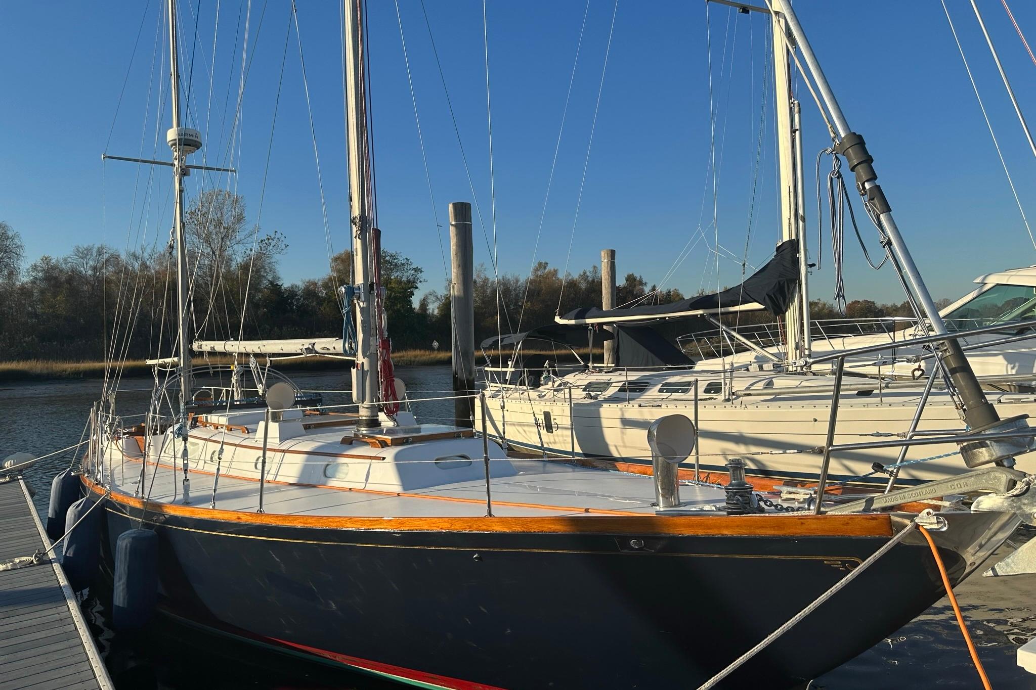 1970 Hinckley Bermuda 40 sailboat docked at marina under clear blue sky.