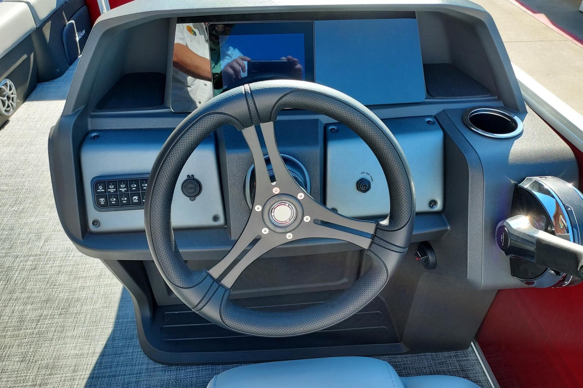 2026 Sun Tracker Party Barge 22 DLX dashboard with steering wheel and controls.