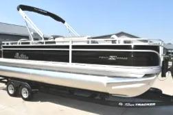 2026 Sun Tracker Fishin' Barge 22 DLX pontoon boat on trailer, side view.