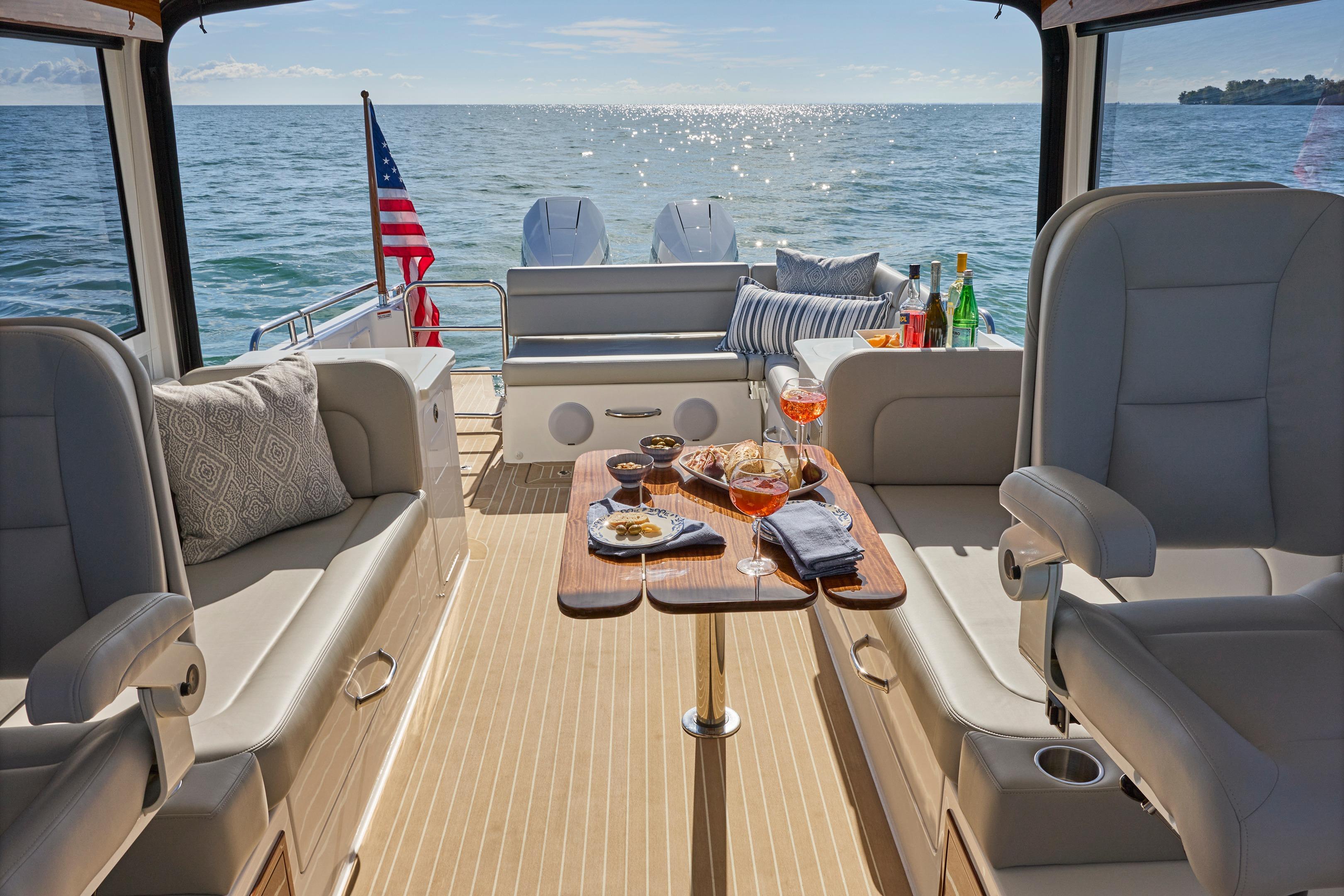 Luxurious 2026 MJM 38x yacht interior with elegant seating, table, and ocean view.