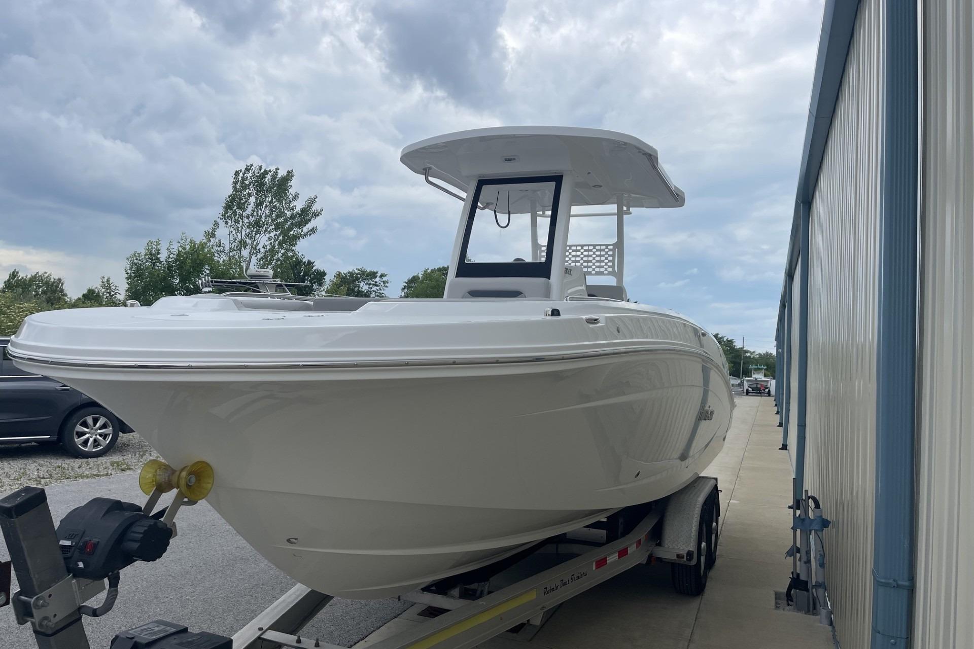 2026 Hurricane Center Console 24 OB boat on trailer, parked outdoors under cloudy sky.