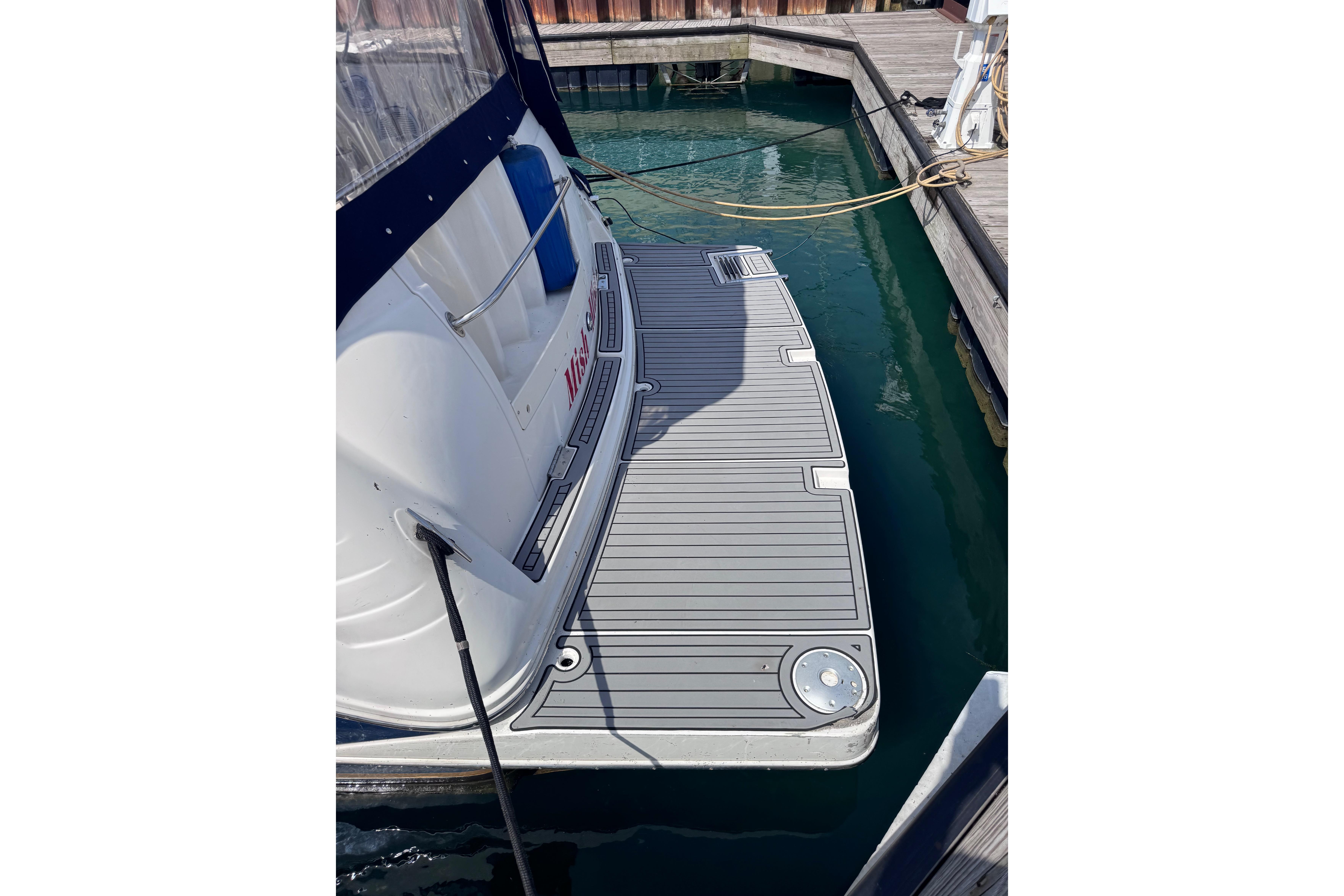2003 Rinker Fiesta Vee 312 boat docked, featuring a spacious swim platform.