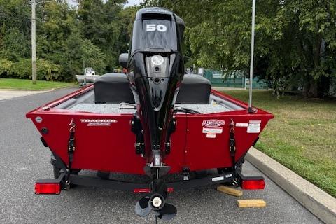2026 Tracker Pro 170 boat with 50 HP engine, parked on a street.