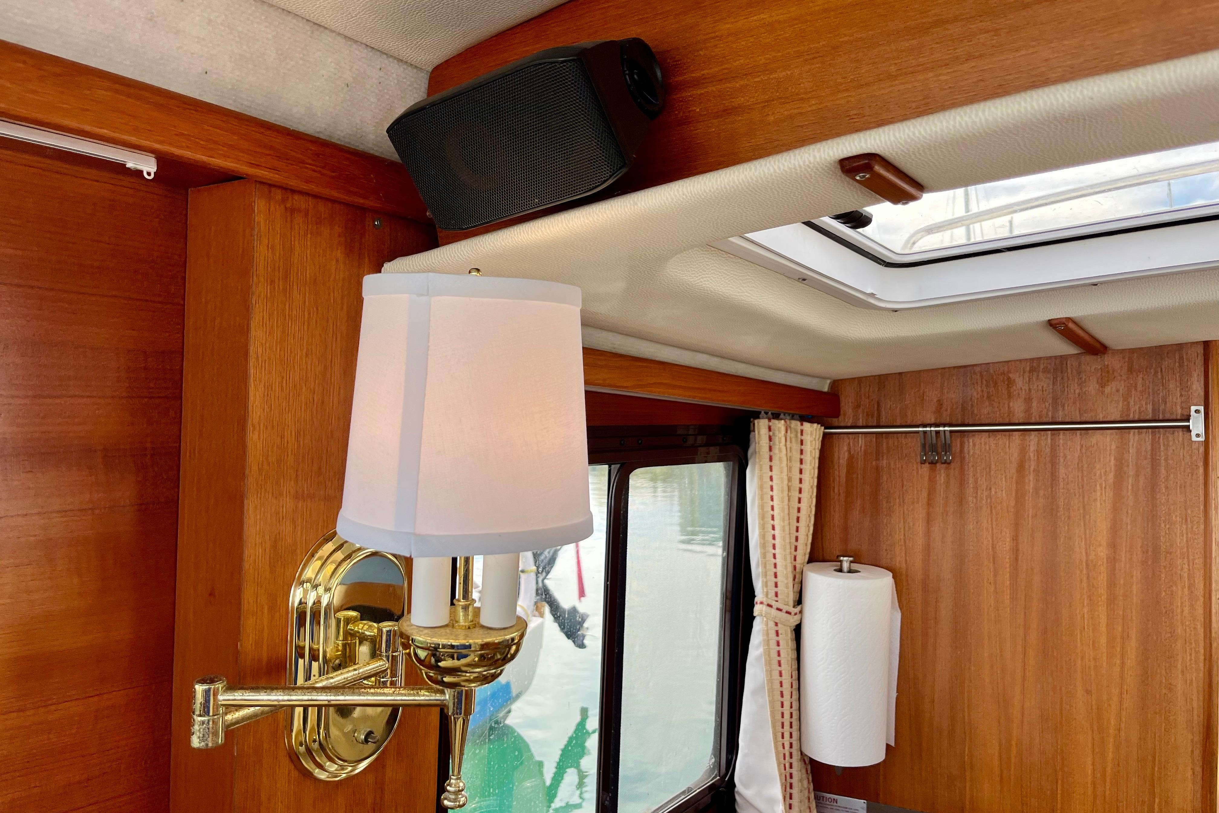 Interior of 2013 Ranger Tugs R-27 with brass wall lamp and wood paneling.