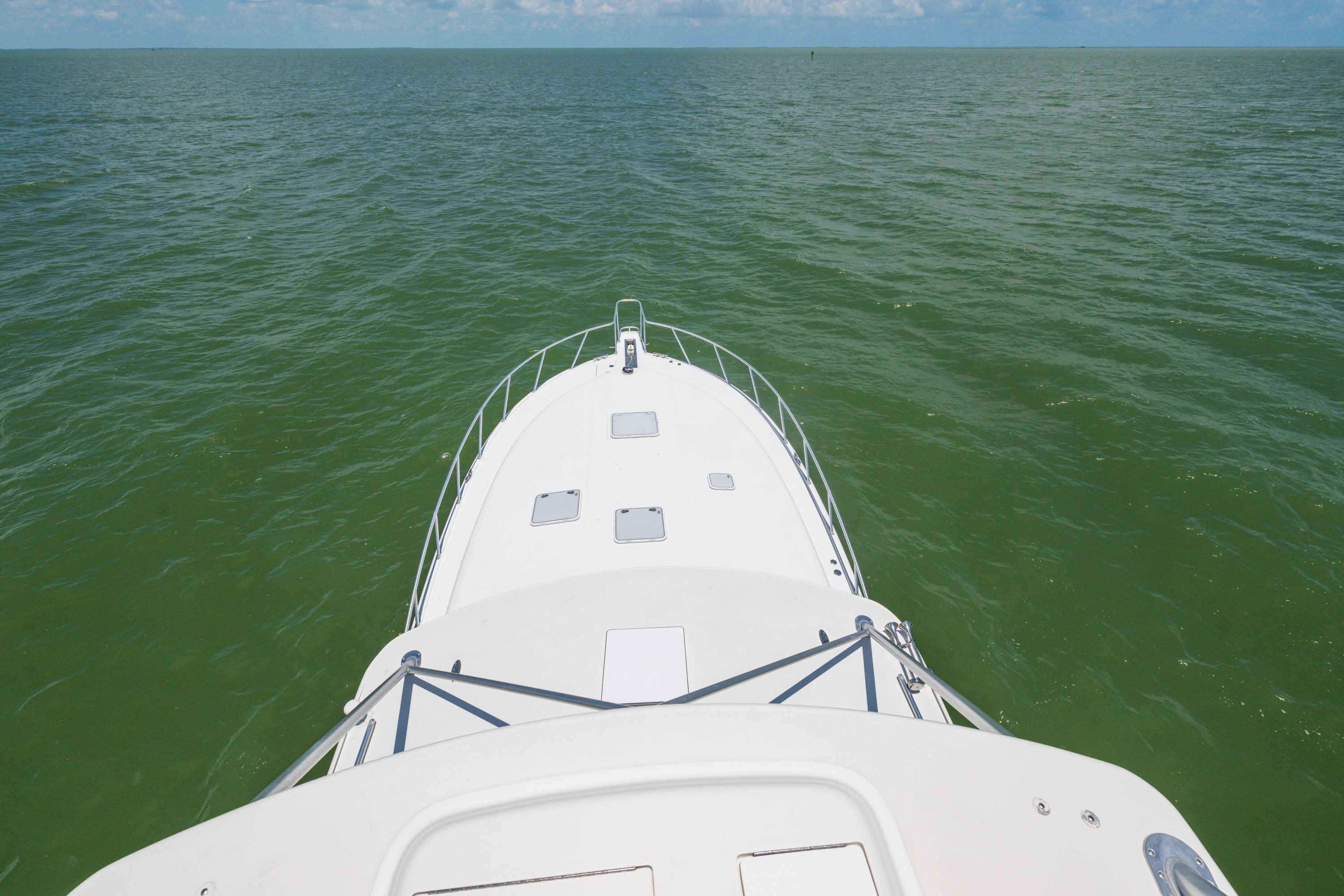 Bow view of 2010 Cabo 45 Express yacht cruising on open sea.