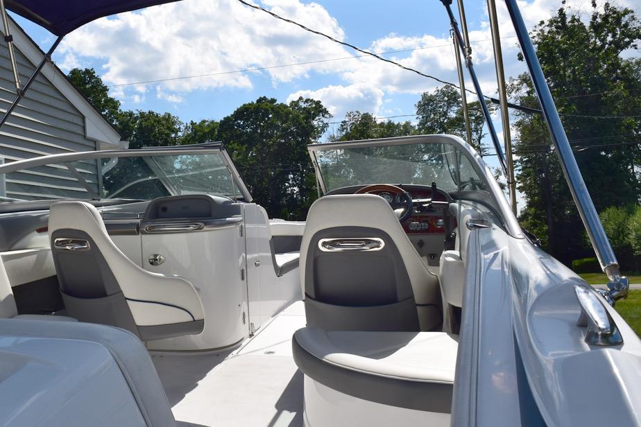 2006 Cobalt 240 boat interior with seating and steering wheel under blue sky.