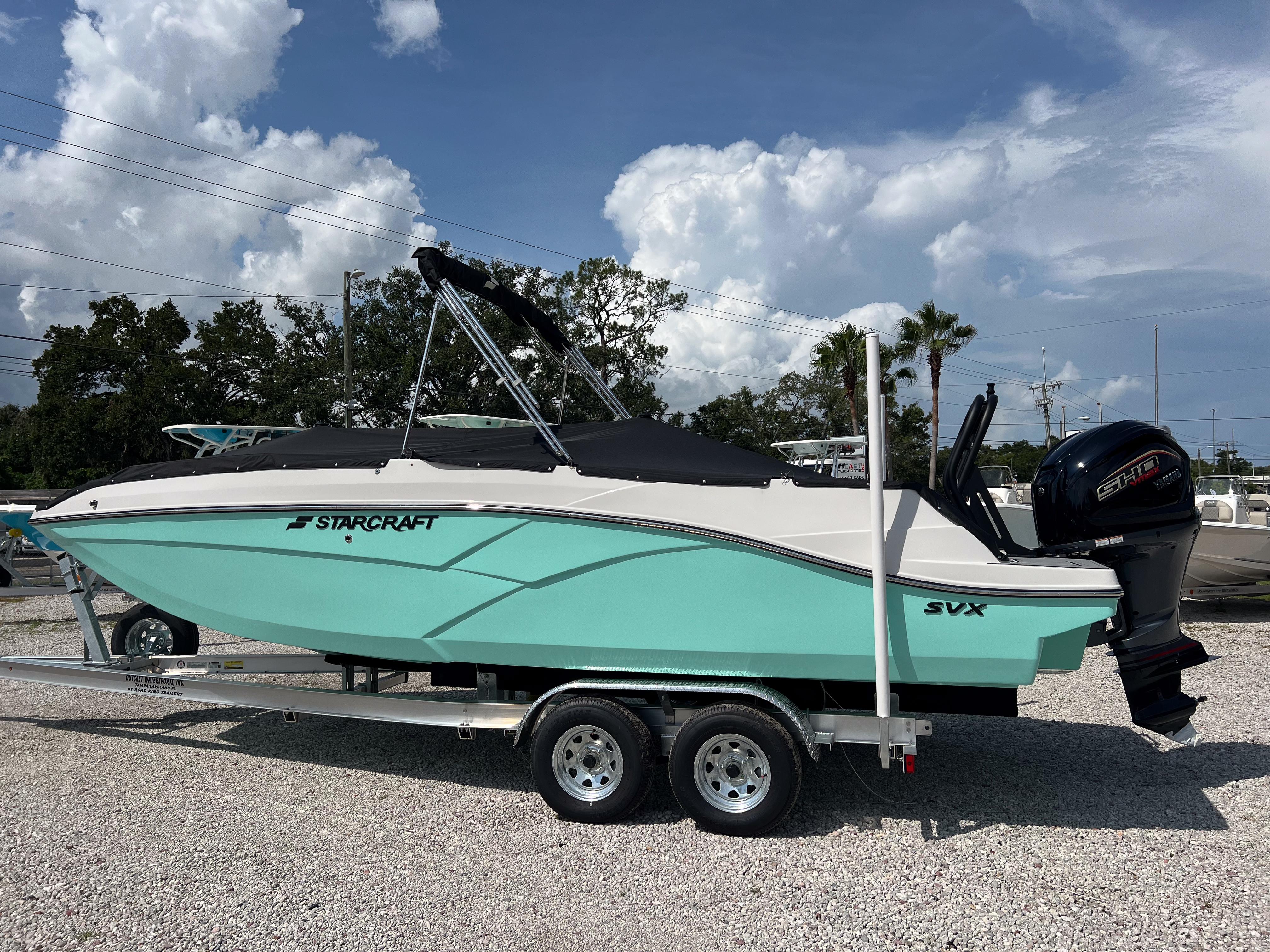 2026 Starcraft SVX 231 OB boat on trailer, turquoise hull, outboard motor, sunny day.