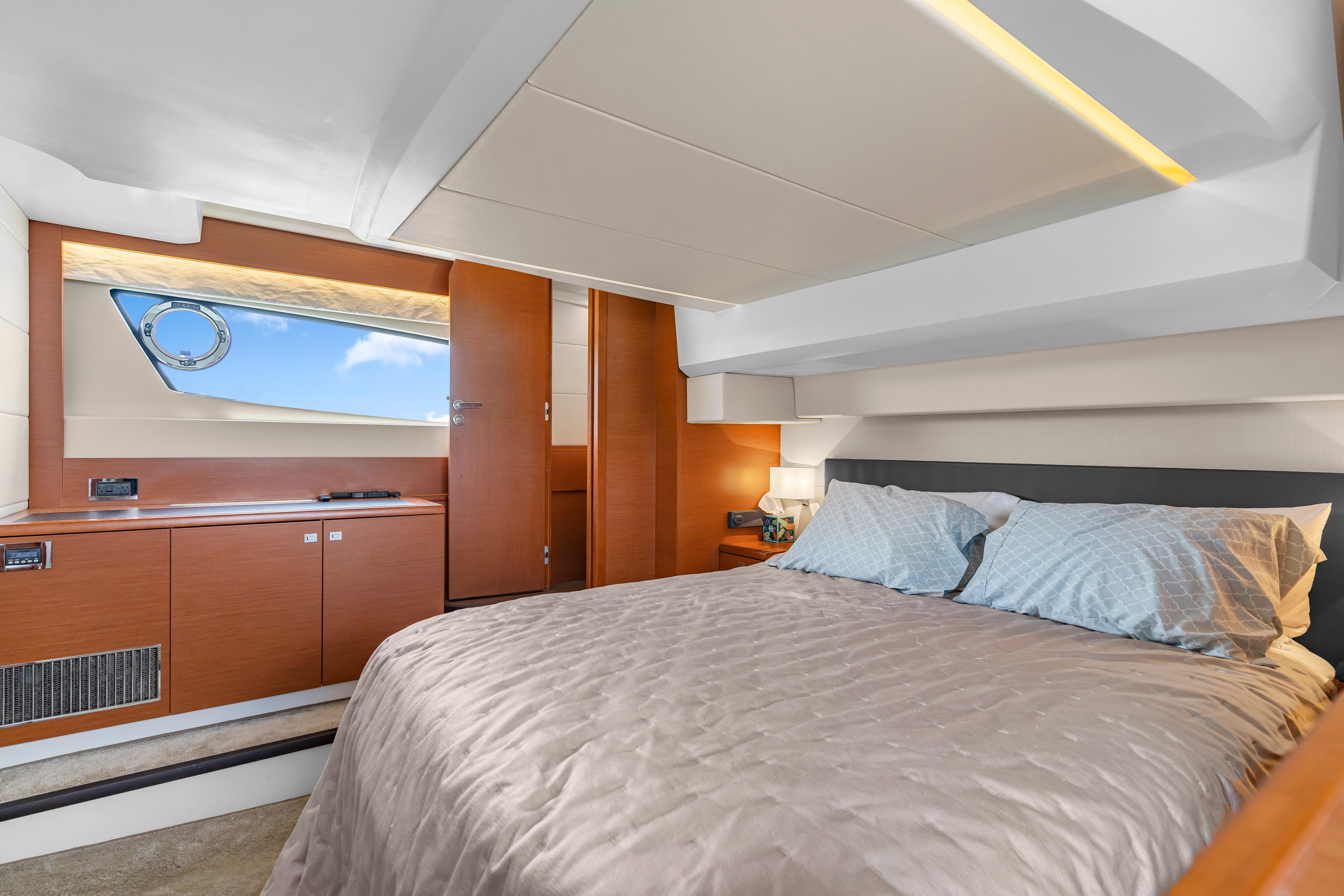 Luxurious cabin interior of a 2017 Prestige 500 yacht with elegant bedding and wooden accents.