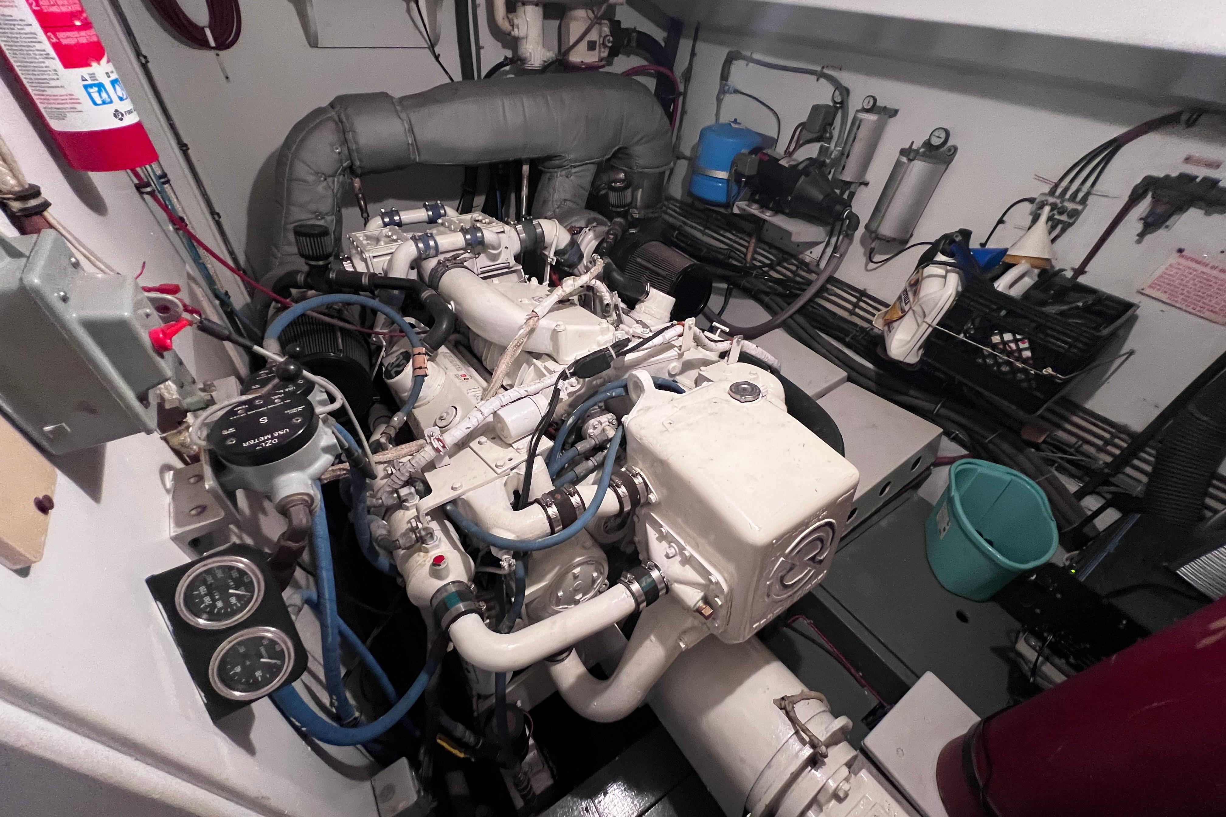 Engine room of a 1987 Hatteras 70 Cockpit Motor Yacht, showcasing mechanical components.