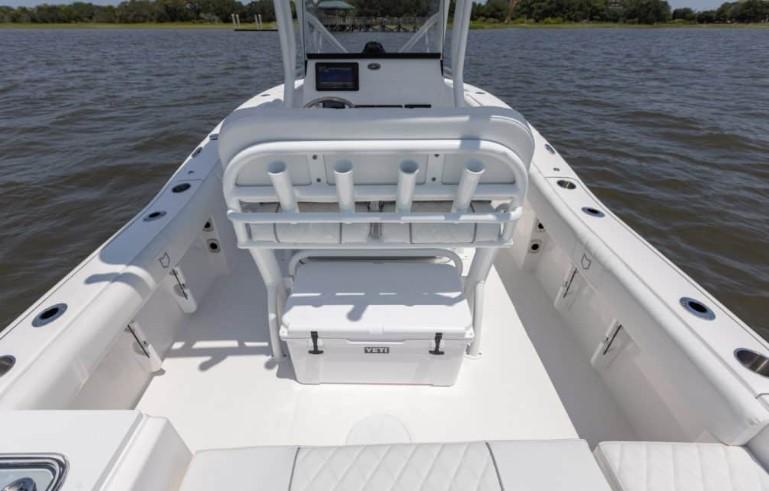 2026 Sea Fox 228 Commander boat interior with seating and rod holders on a calm water body.
