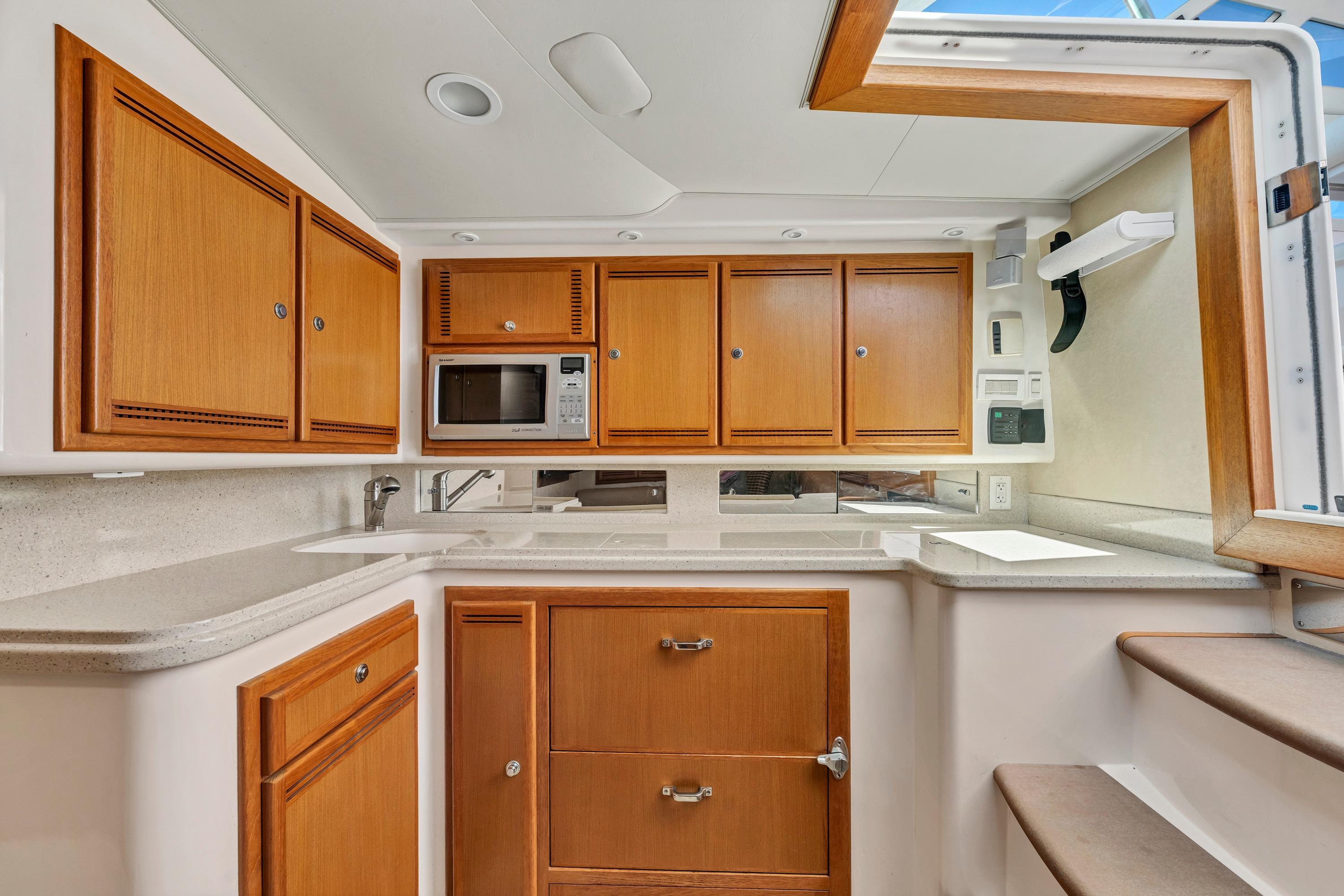 2010 Cabo 45 Express yacht kitchen with wooden cabinets and modern appliances.