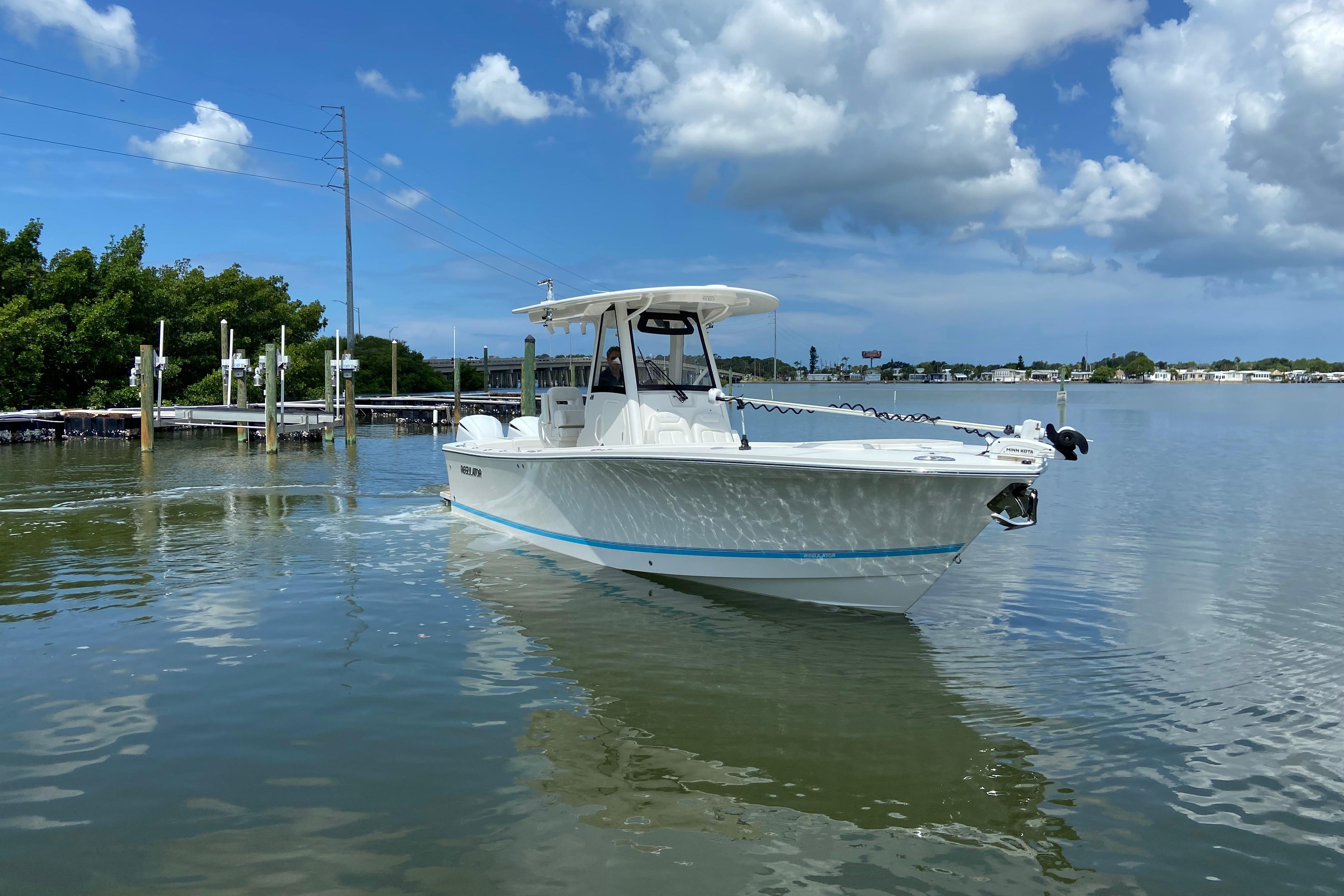 2021 Regulator 28 boat on calm water under a partly cloudy sky.