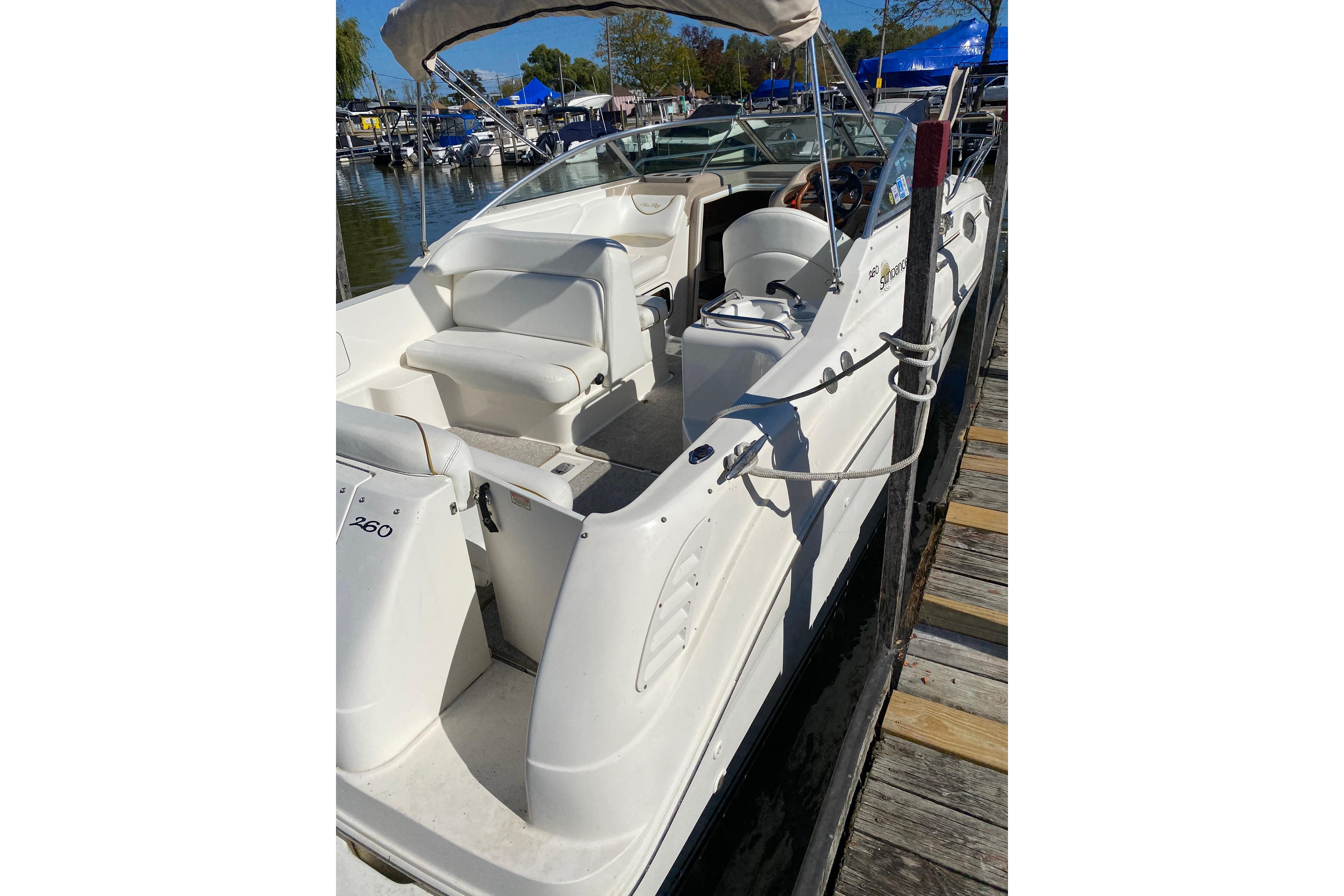 2001 Sea Ray Sundancer 260 boat docked, featuring white seating and sleek design.