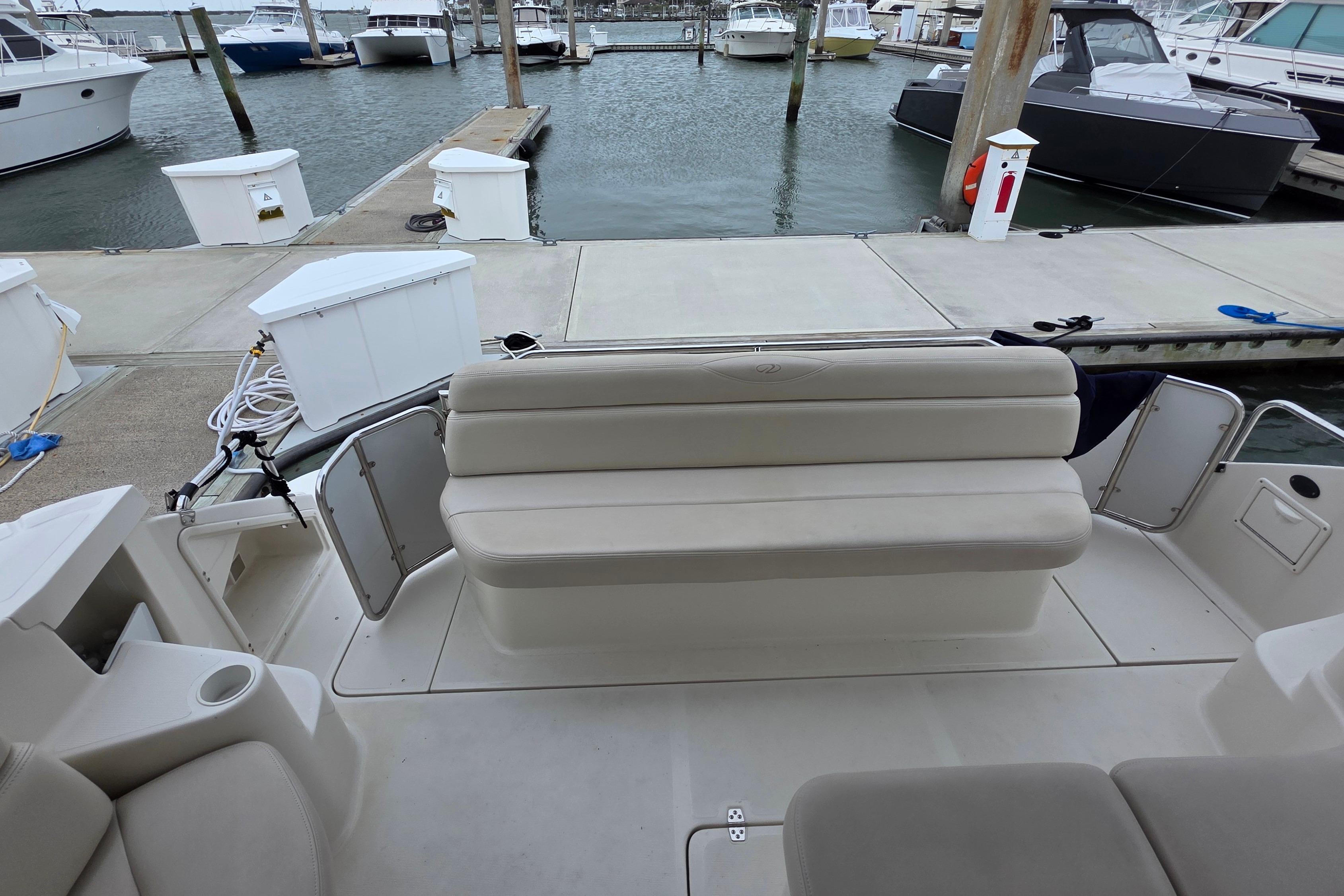 2002 Regal Commodore 4260 yacht with beige seating at a marina dock.