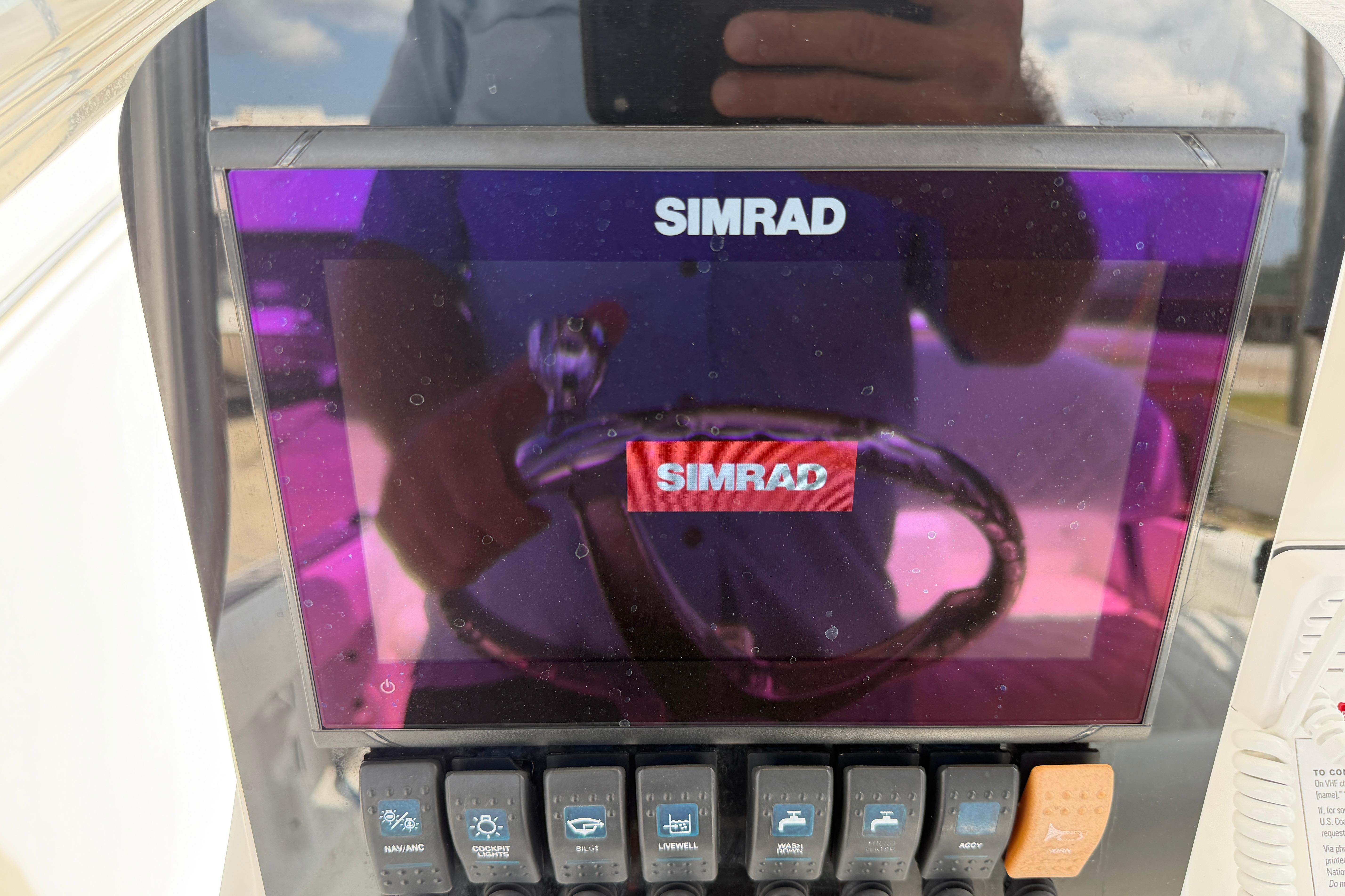 Simrad display on 2015 Sea Hunt Triton 225 boat dashboard with control switches.