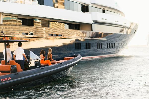 2024 Onda Magna boat near a luxury yacht with people onboard.