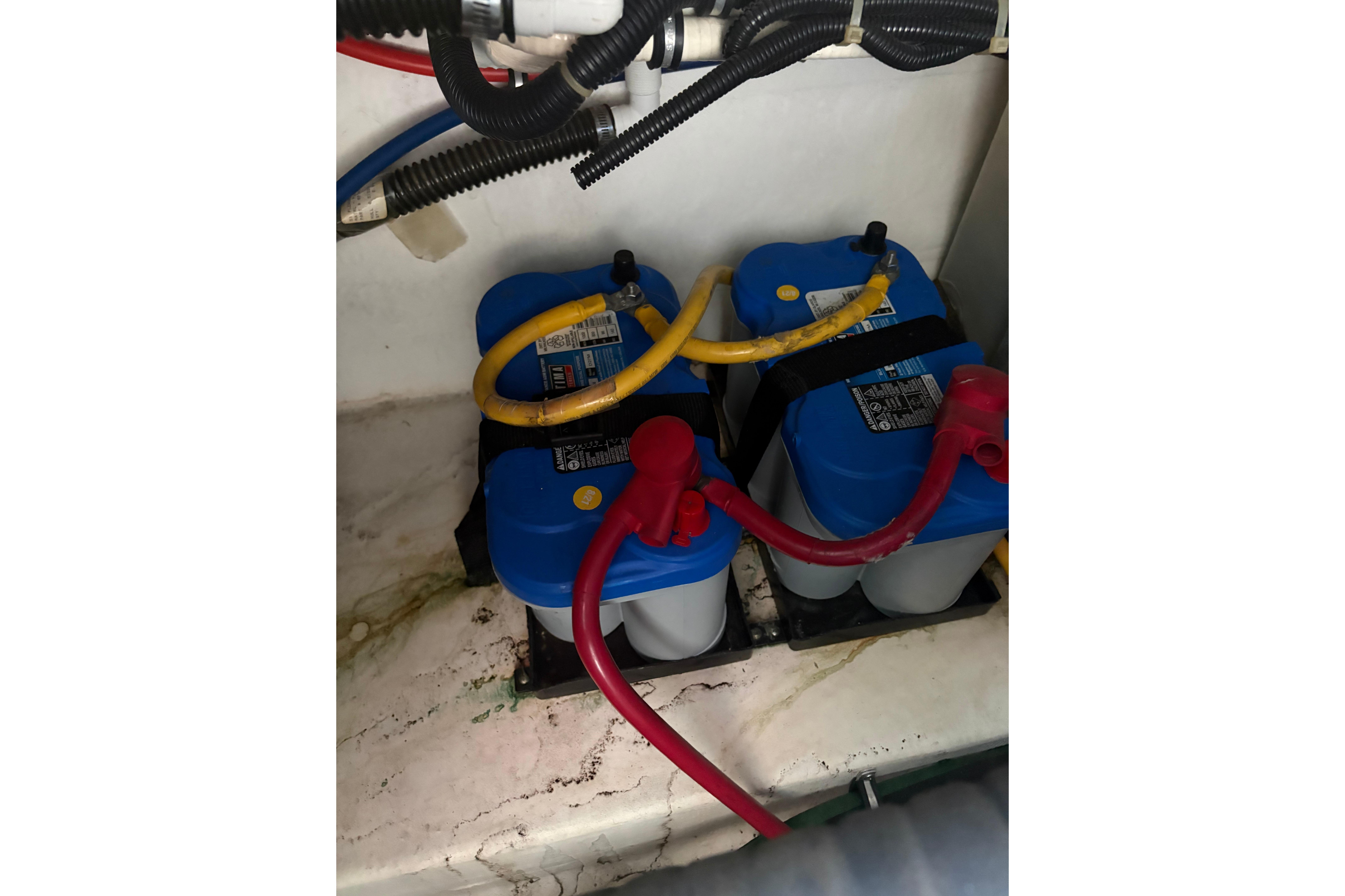 Batteries in a 1999 Tiara Yachts 3100 Open, connected with red and yellow cables.