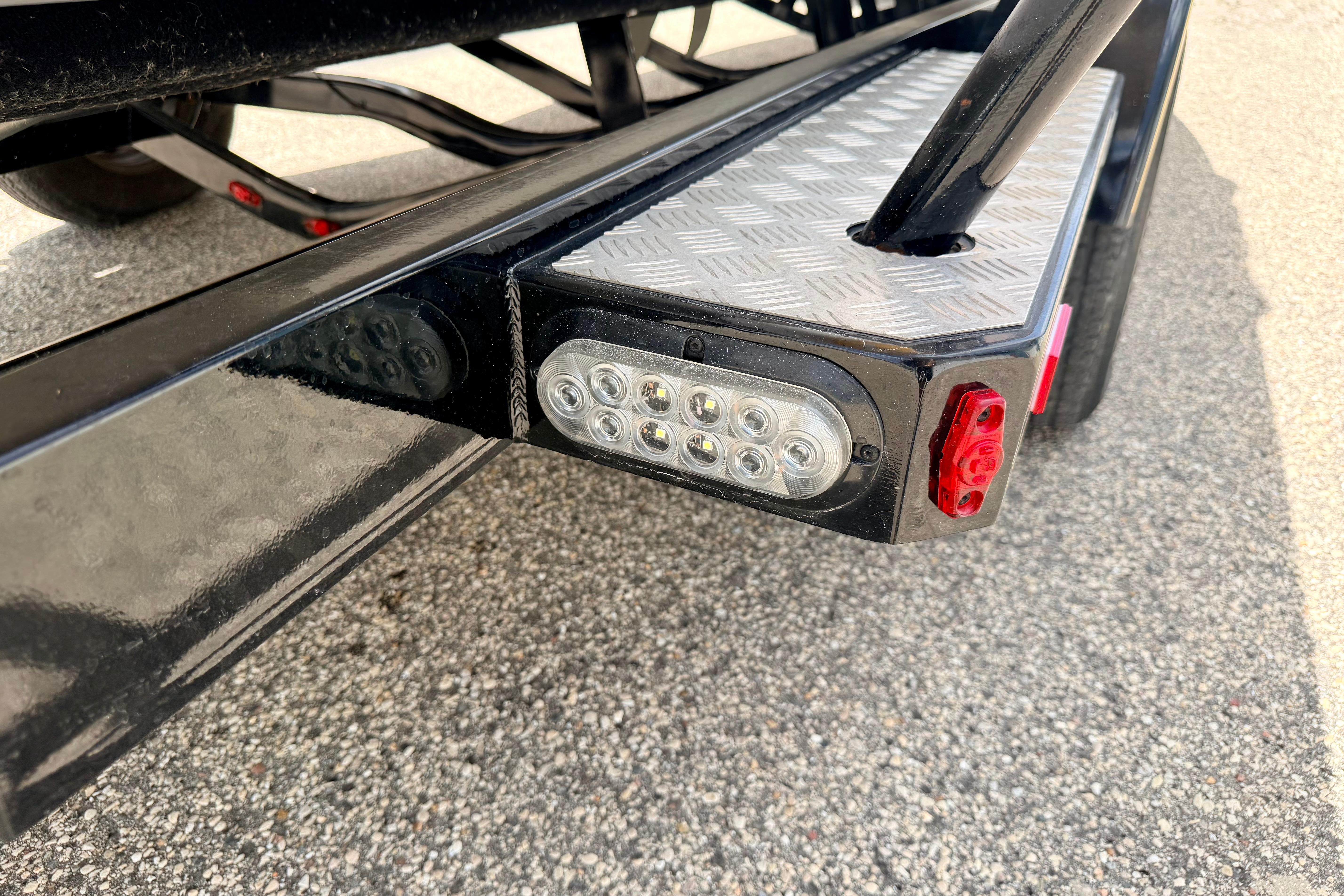 Close-up of 2014 Tigé R20 trailer light and step detail on asphalt.