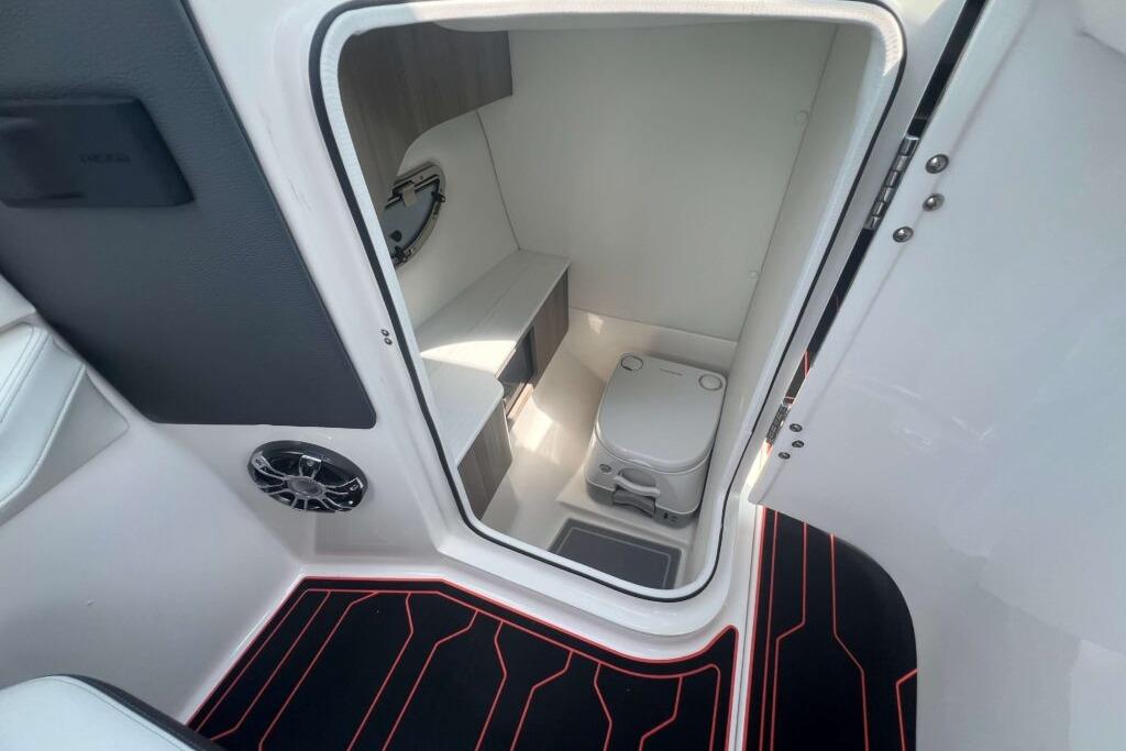 Compact bathroom inside 2023 Regal LS6 Surf boat, featuring modern amenities and sleek design.