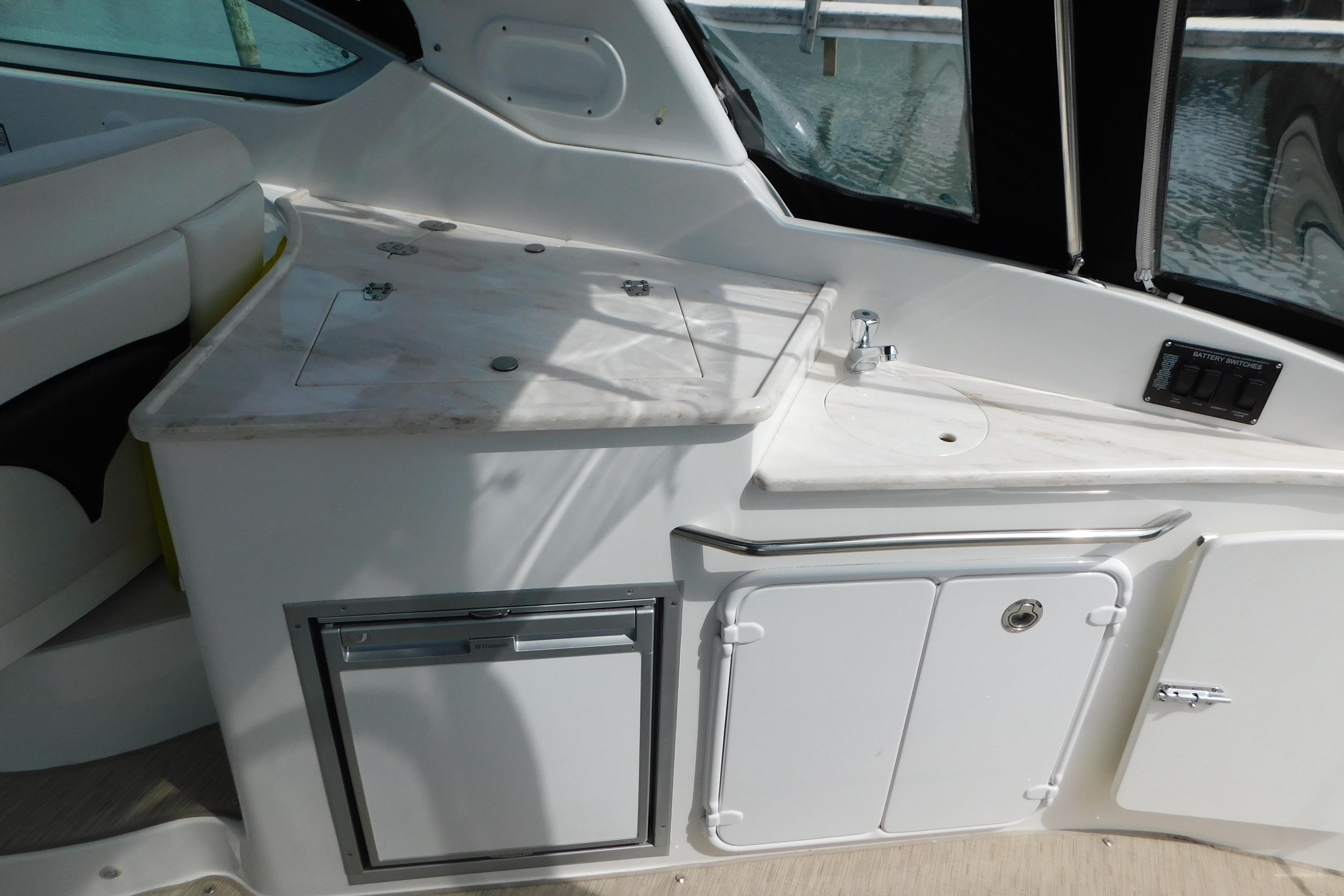 2017 Rinker EX 320 boat interior with kitchenette and storage compartments.