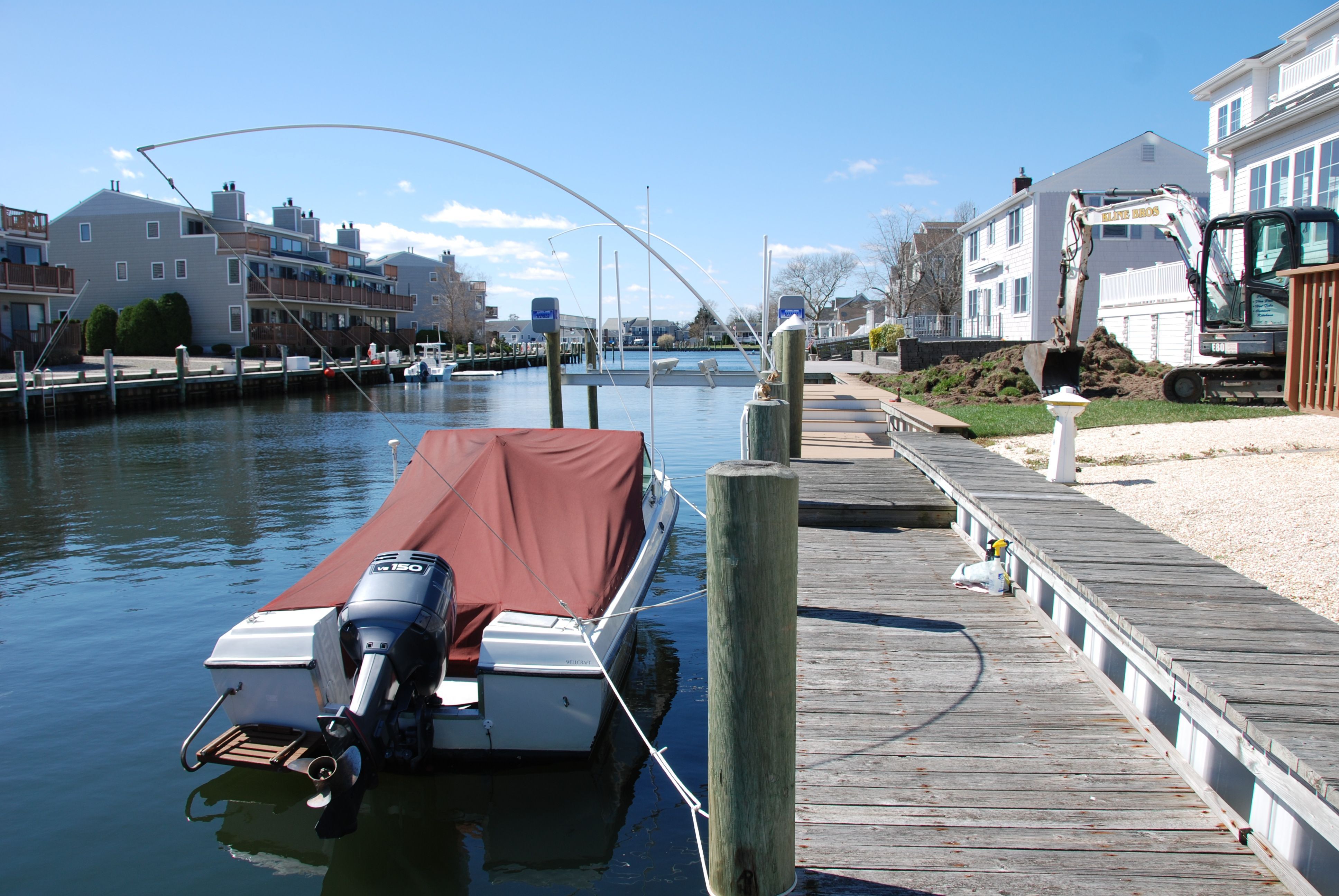 A 1987 Wellcraft V-20 Steplift is docked in a calm residential area.