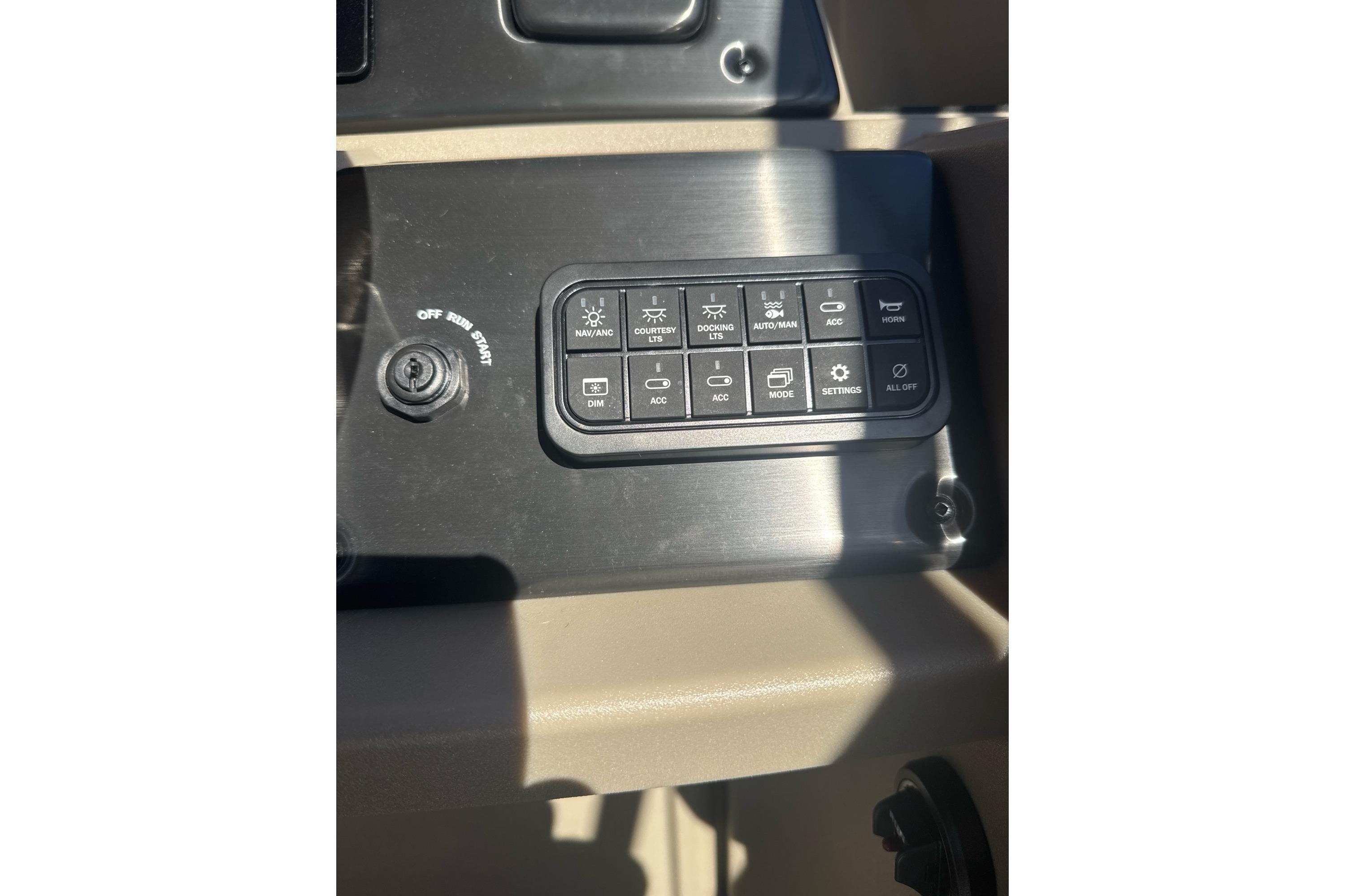 Control panel of 2025 Sun Tracker SportFish 22 DLX boat with various switches.