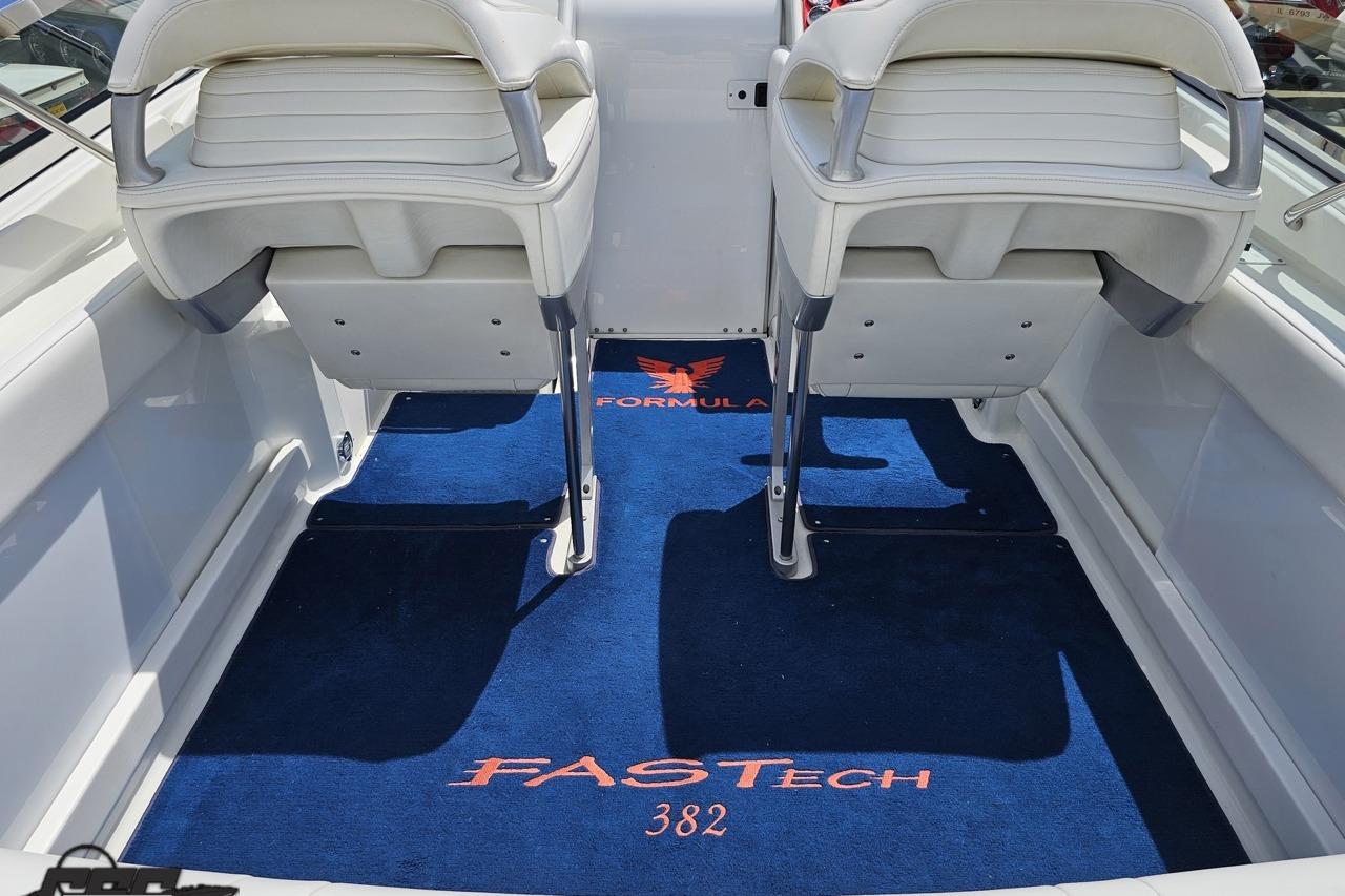 Interior of a 2002 Formula 382 FASTech boat with blue carpet and white seats.