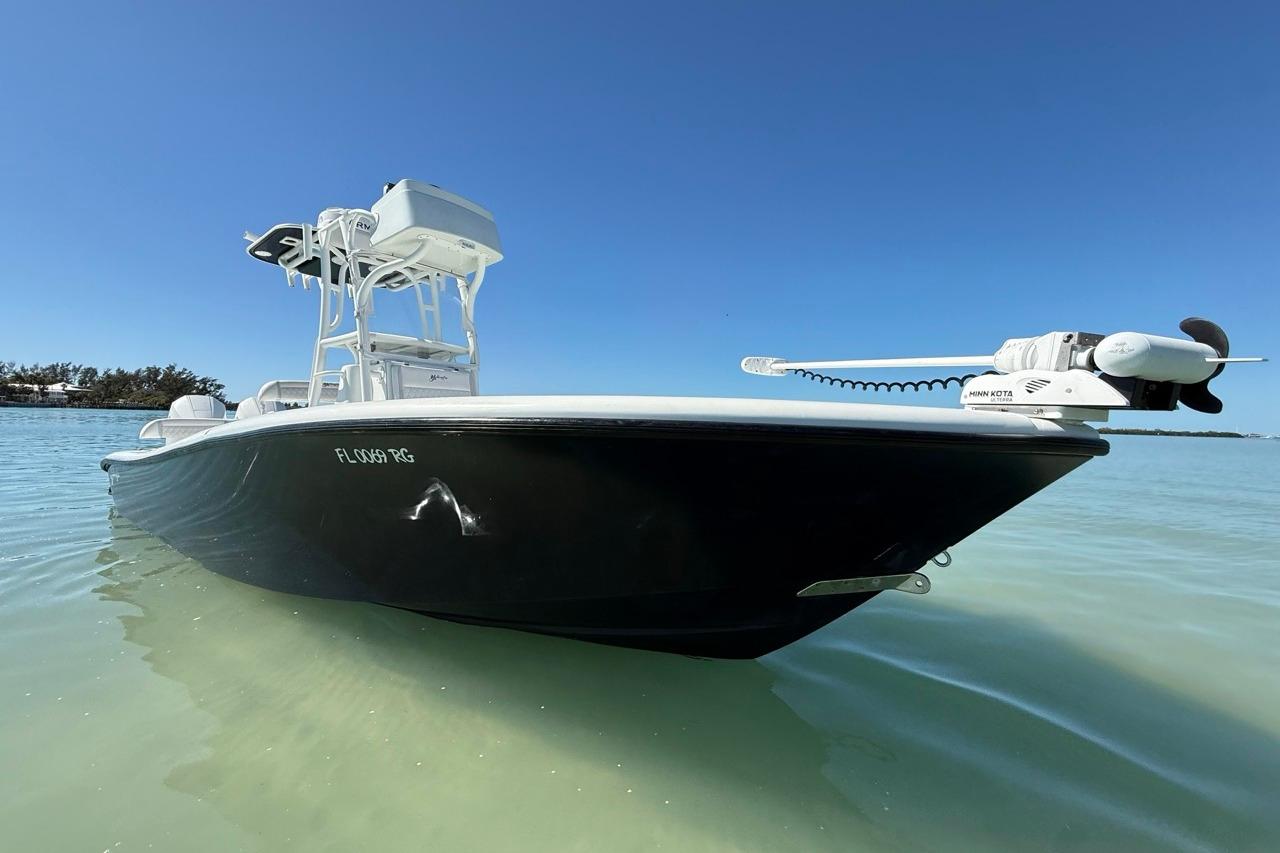 2017 Yellowfin 26 Hybrid boat on clear water under blue sky.