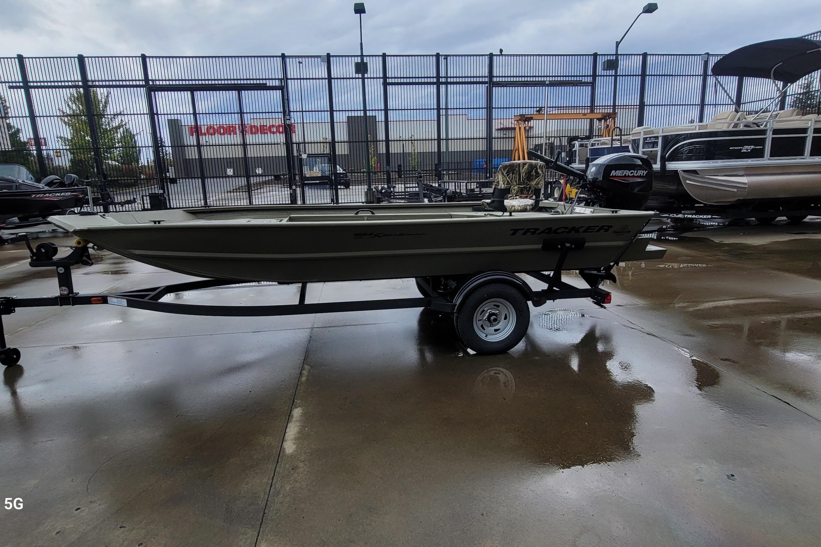 2026 Tracker Grizzly 1654 T Sportsman boat on trailer in outdoor showroom.